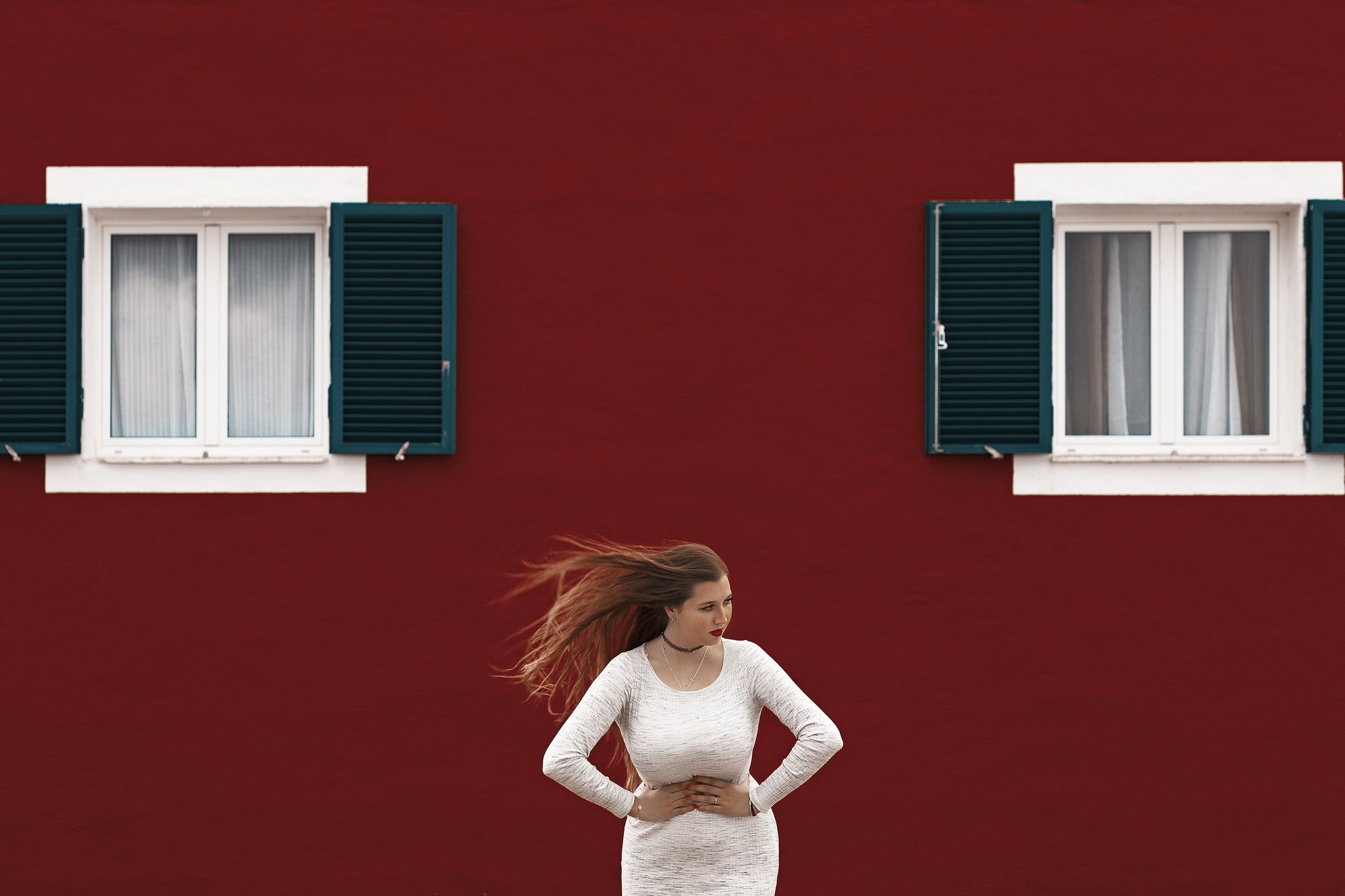 Woman in white dress in front of red wall with windows HD Wallpaper