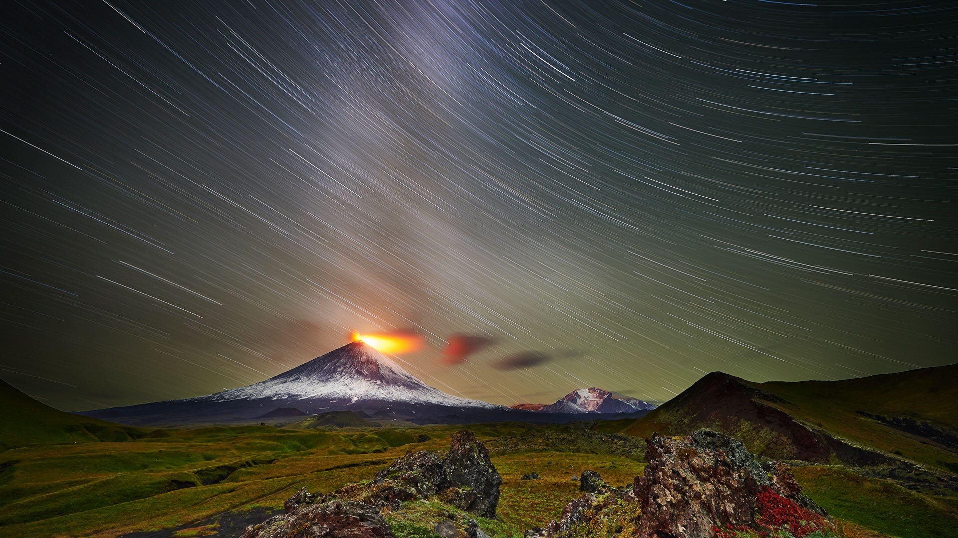 Volcano erupting at night with star trails HD Wallpaper