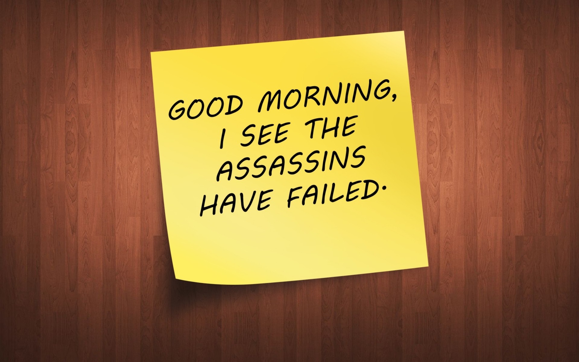 Yellow sticky note with text about assassins on a wooden background HD Wallpaper