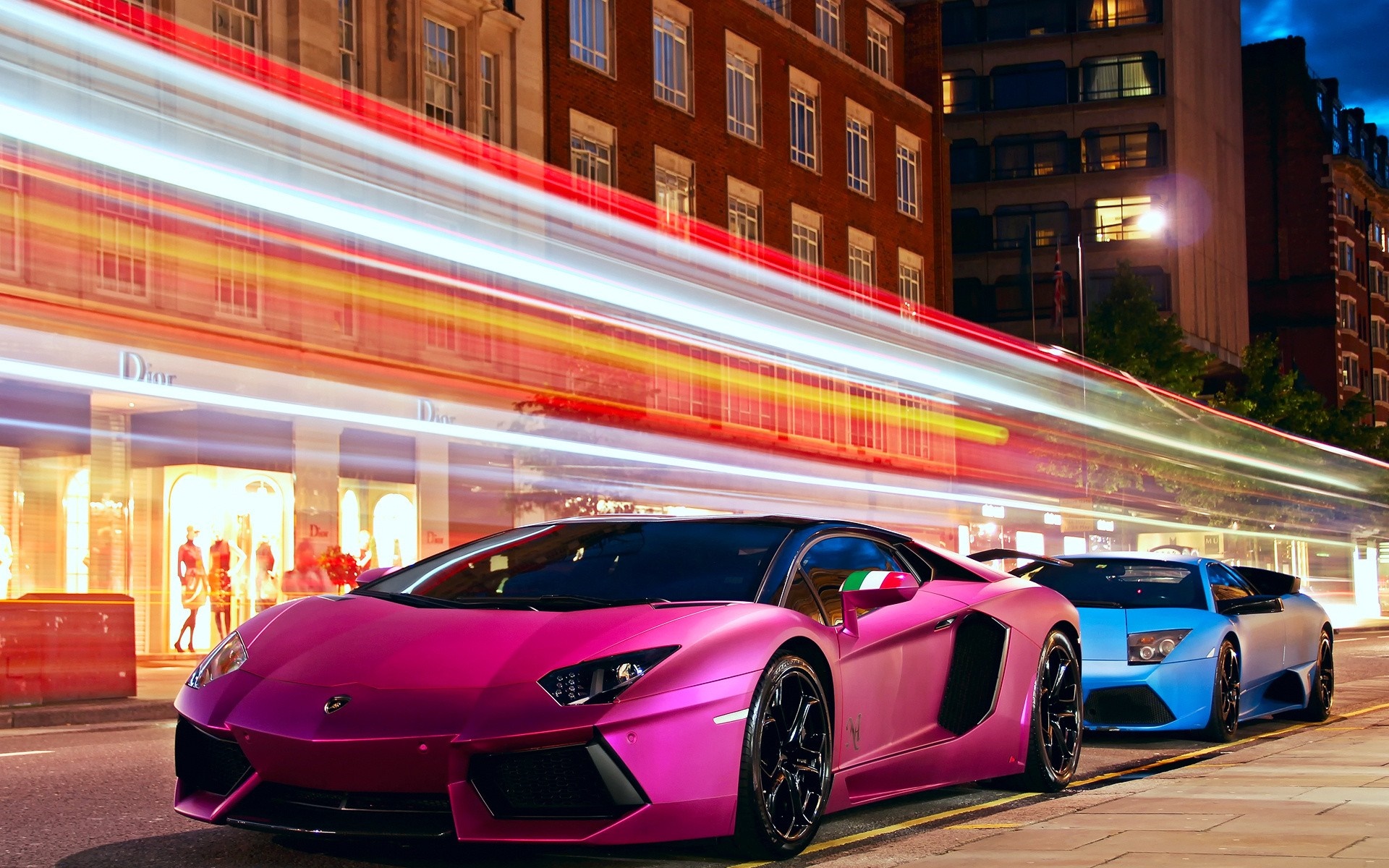 Pink and Blue Lamborghinis on a City Street at Night HD Wallpaper