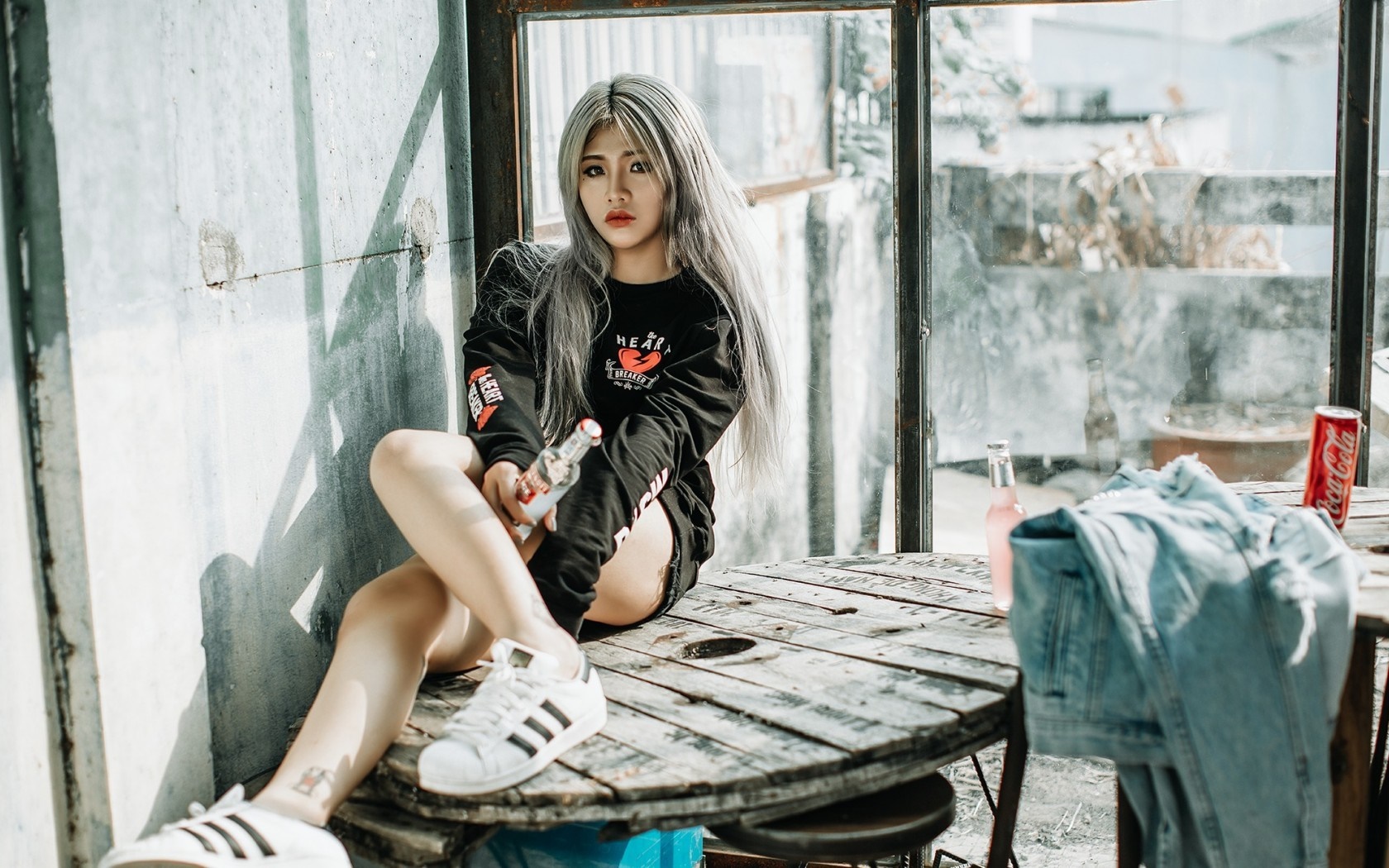 Asian woman with gray hair sitting on a wooden table HD Wallpaper