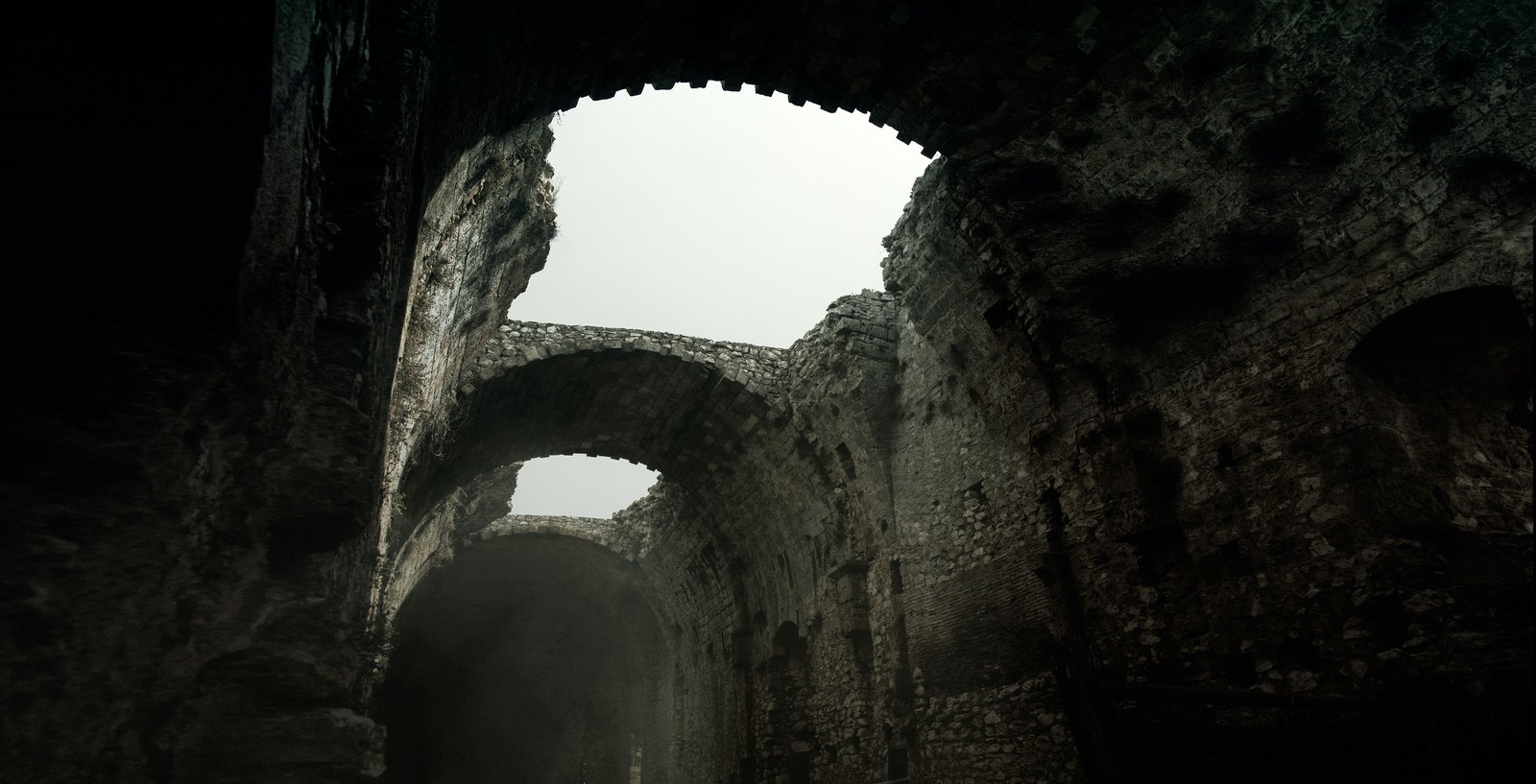 Ancient stone ruins with arches and sky HD Wallpaper