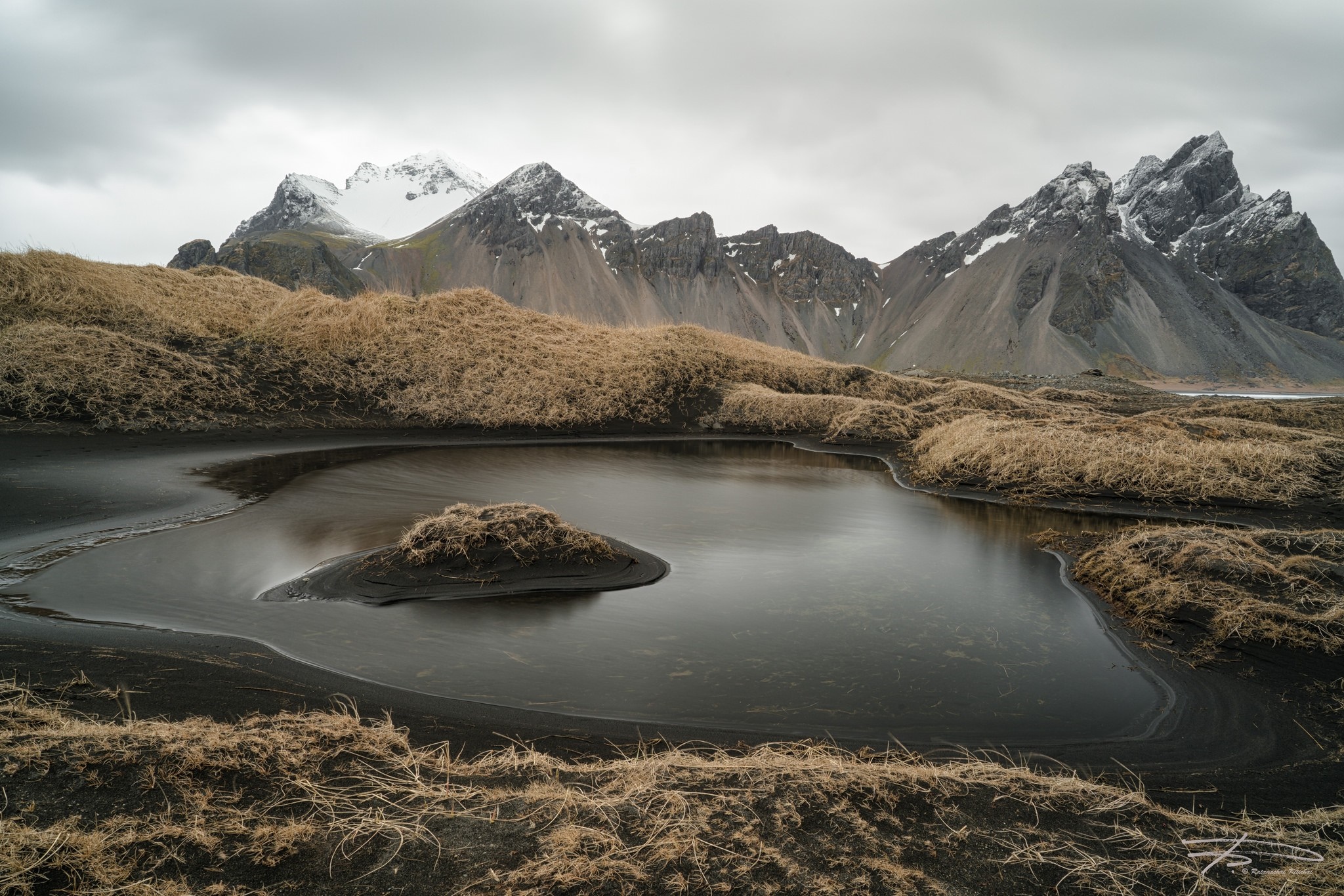 Mountains and a dark lake with dry grass HD Wallpaper