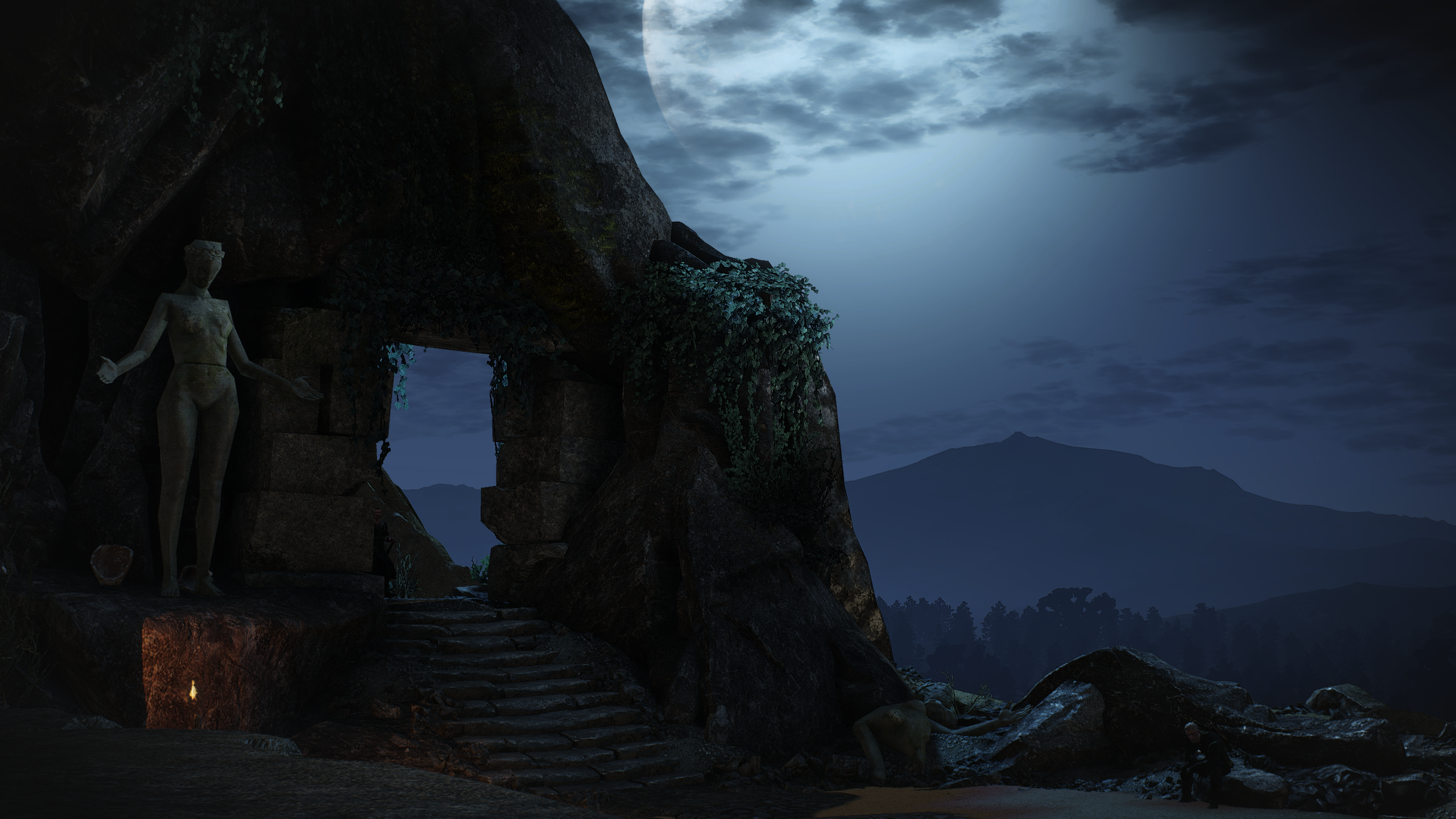 Statue in a cave entrance at night HD Wallpaper