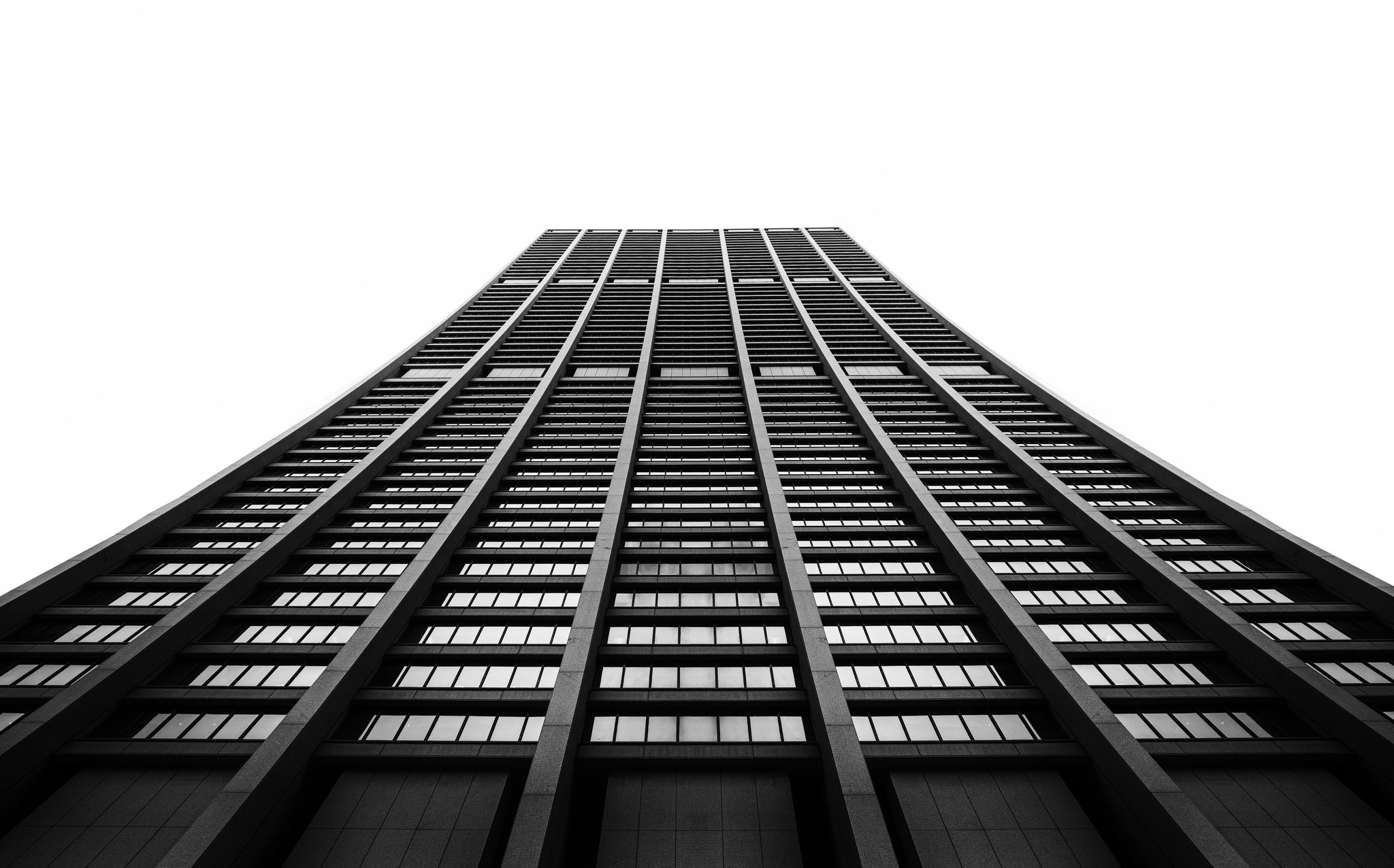 Monochrome view of a tall skyscraper from below HD Wallpaper