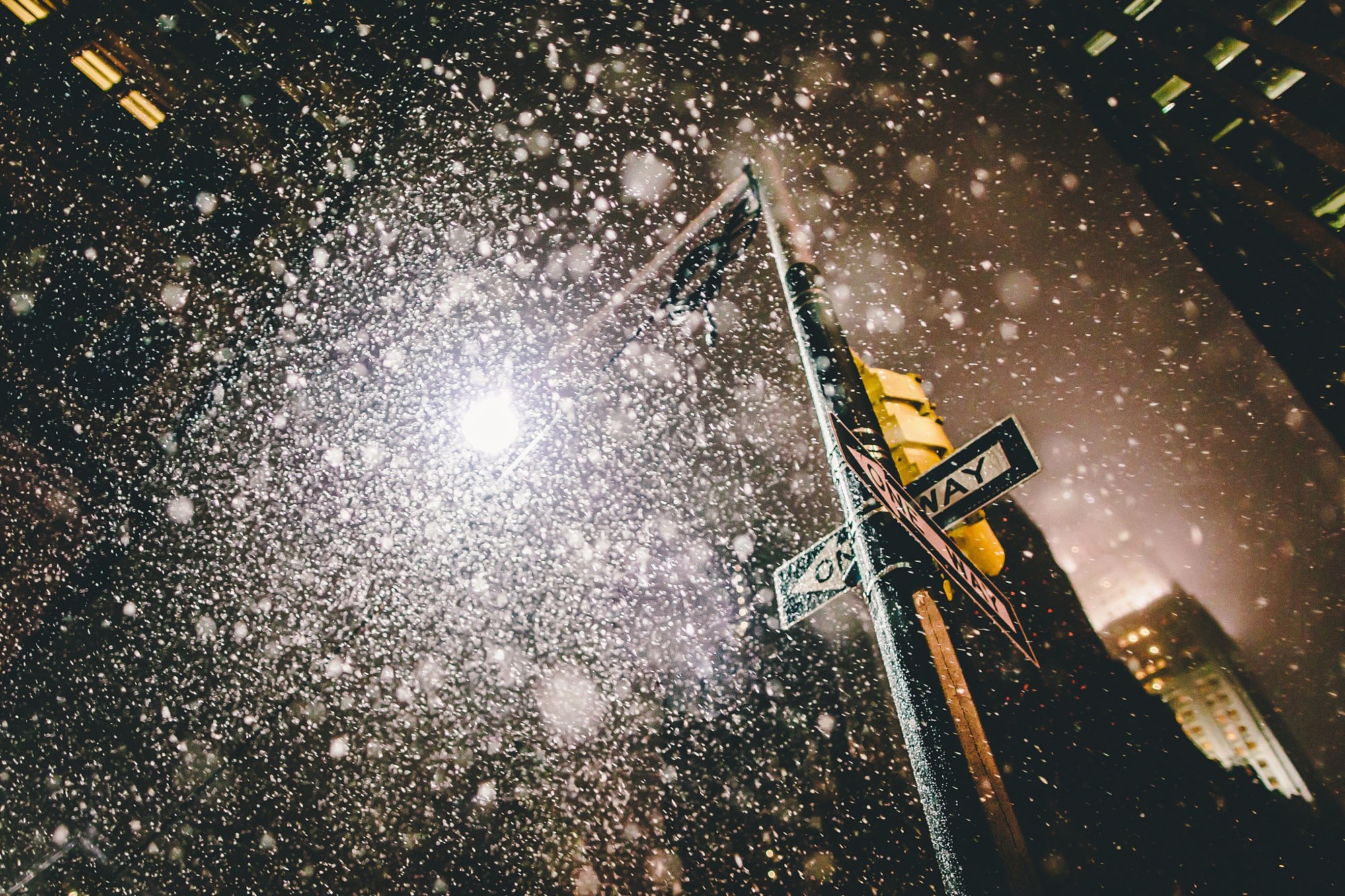 Snow falling on a New York City street at night HD Wallpaper