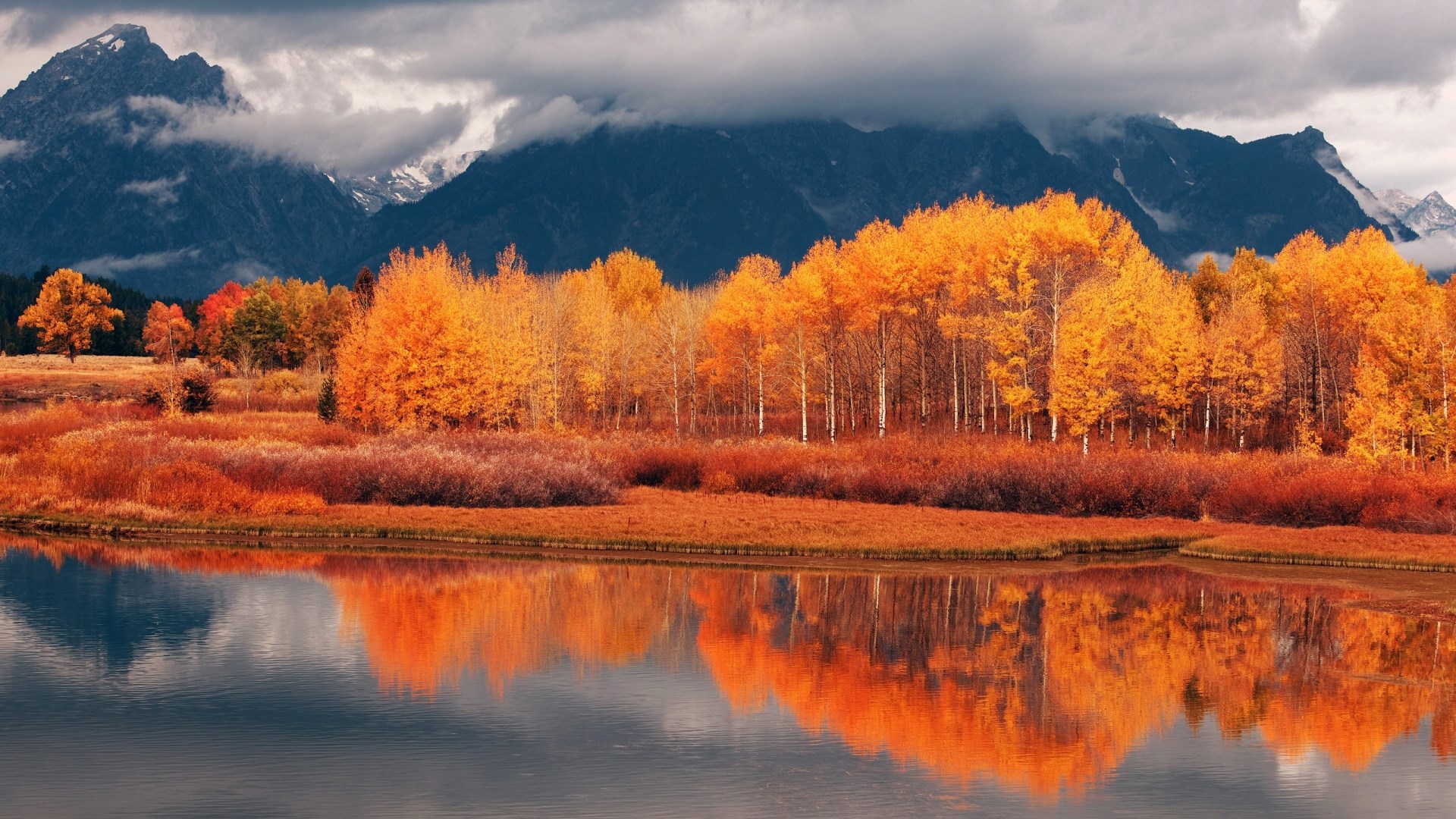 Autumn trees reflected in a lake with mountains HD Wallpaper