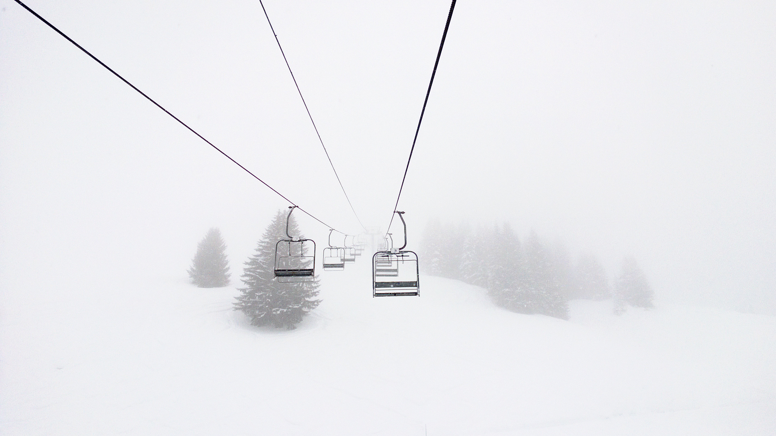 Ski lifts in a snowy winter landscape with pine trees HD Wallpaper
