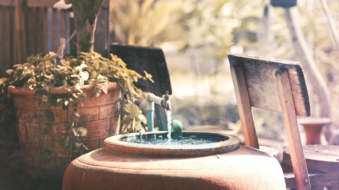Water flowing from a faucet into a large ceramic pot HD Wallpaper