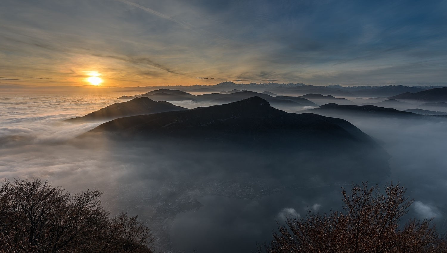 Sunrise over misty mountains and a lake HD Wallpaper