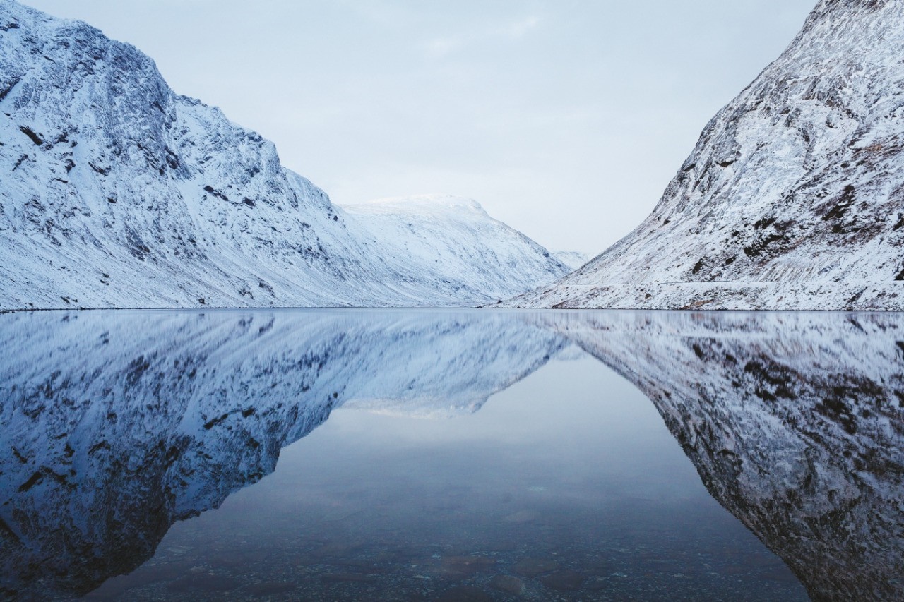 Snow-covered mountains reflected in a calm lake HD Wallpaper
