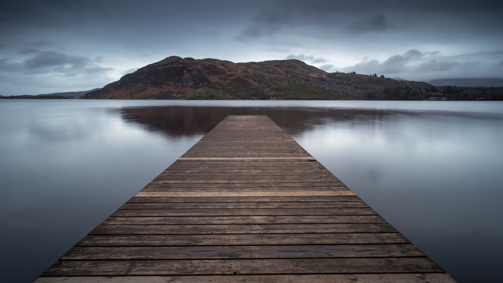 Wooden pier on a calm lake with a mountain in the background HD Wallpaper
