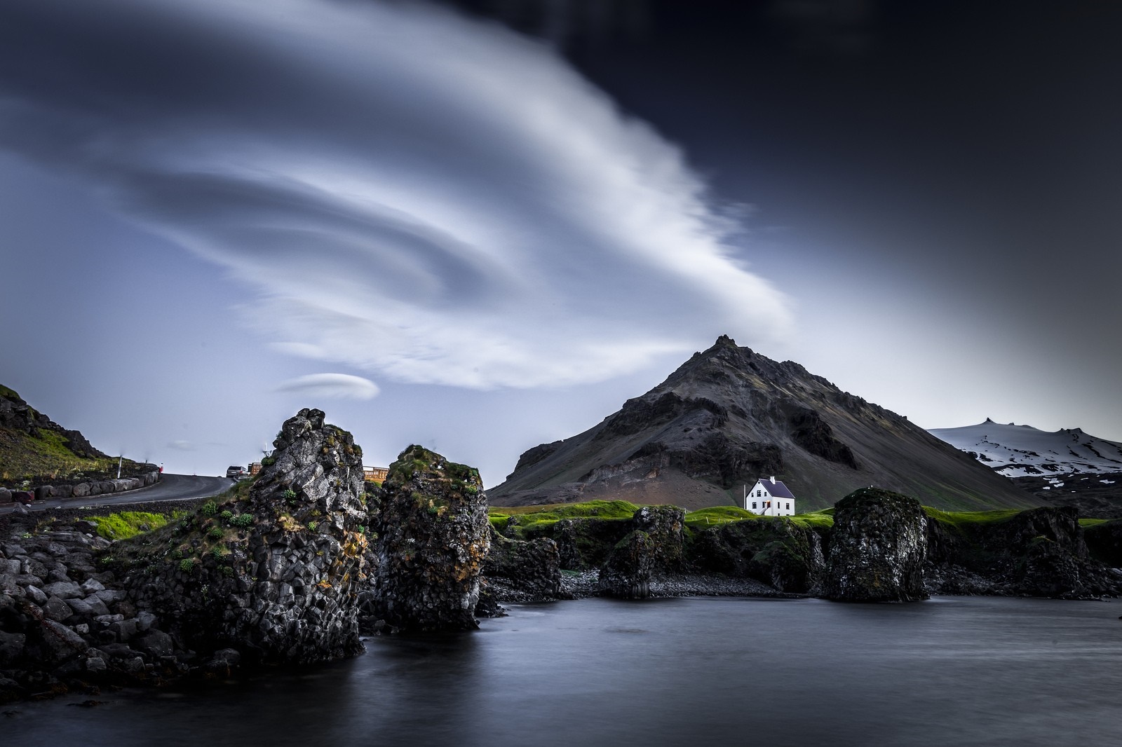 White house on a rocky coast with mountains and lenticular clouds HD Wallpaper