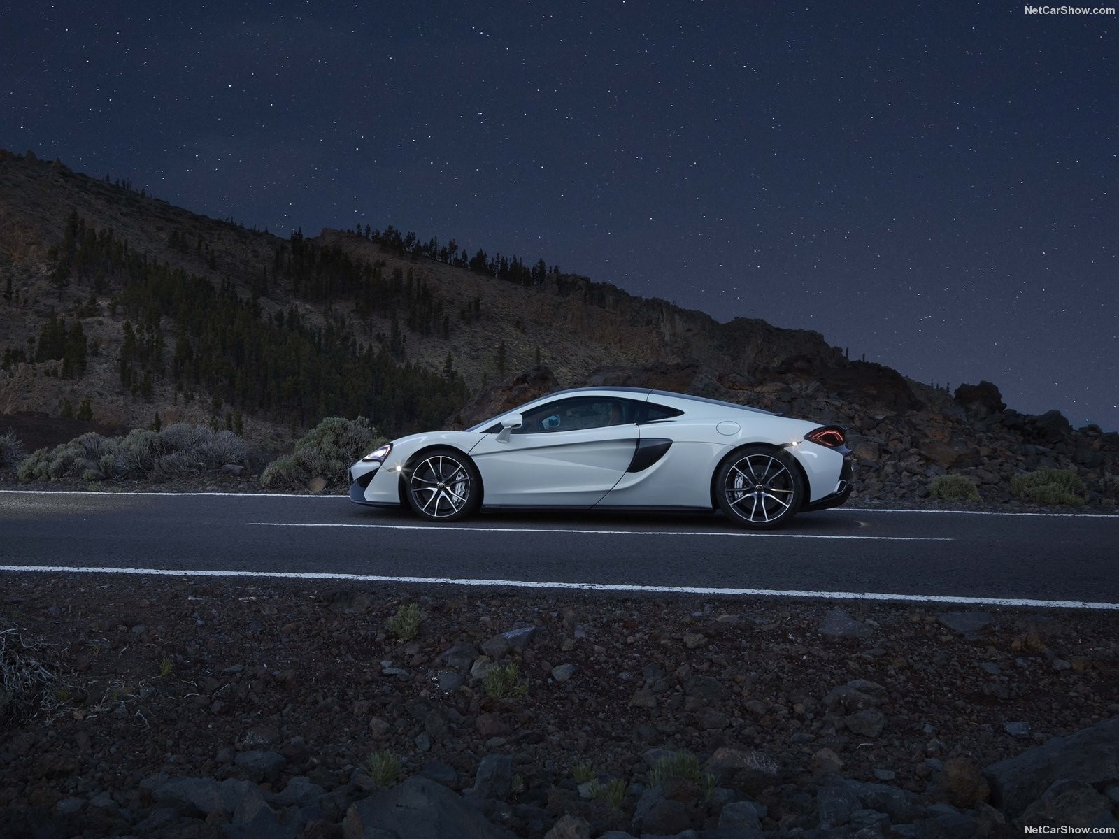 White McLaren 570GT parked on a road at night HD Wallpaper