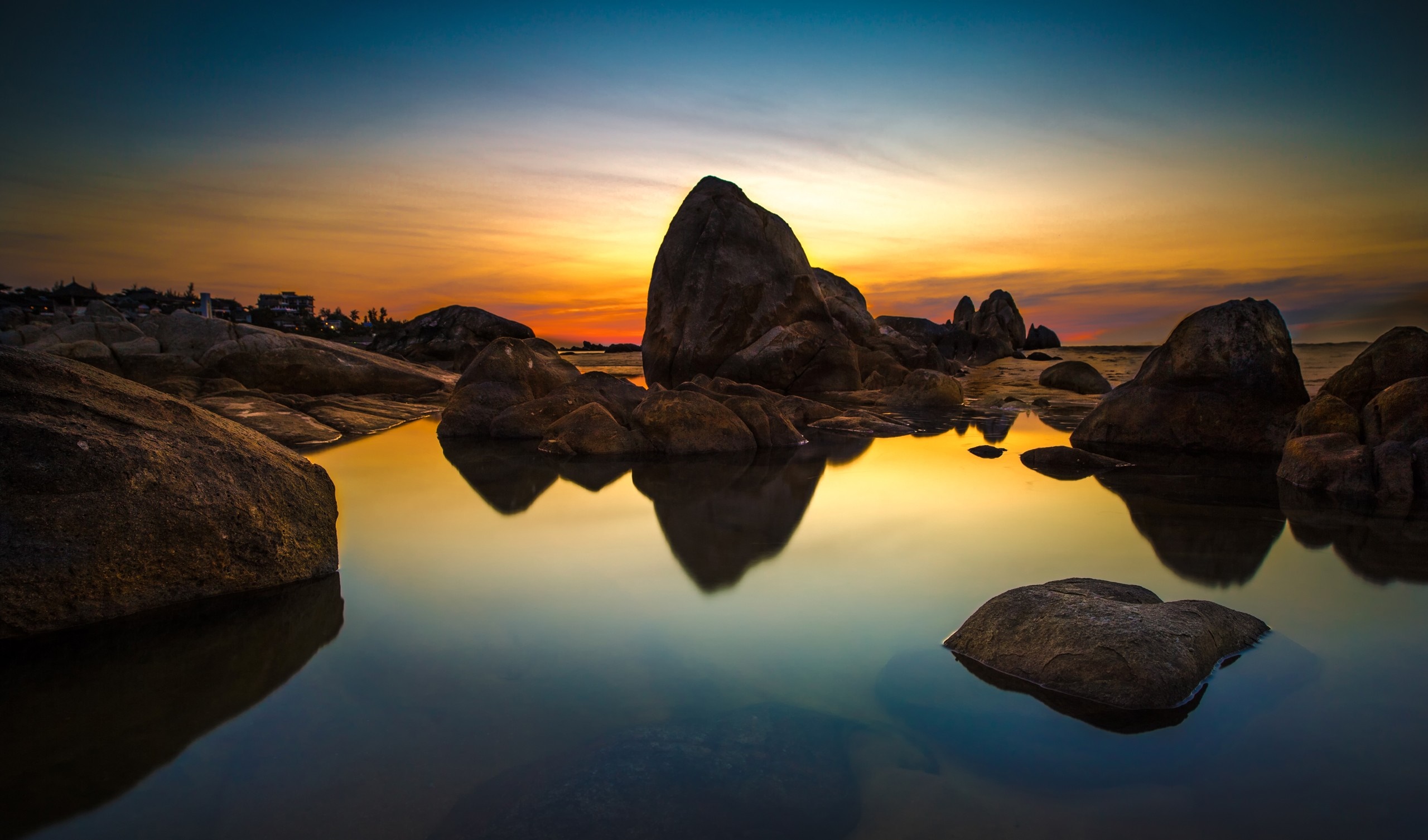 Sunset over rocky coast with calm sea reflection HD Wallpaper