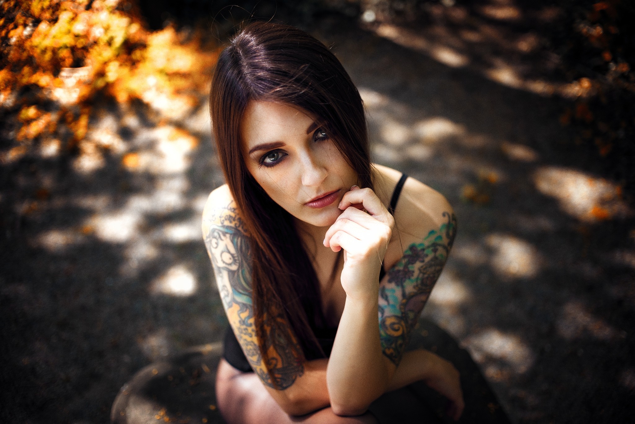 Woman with tattoos sitting outdoors HD Wallpaper