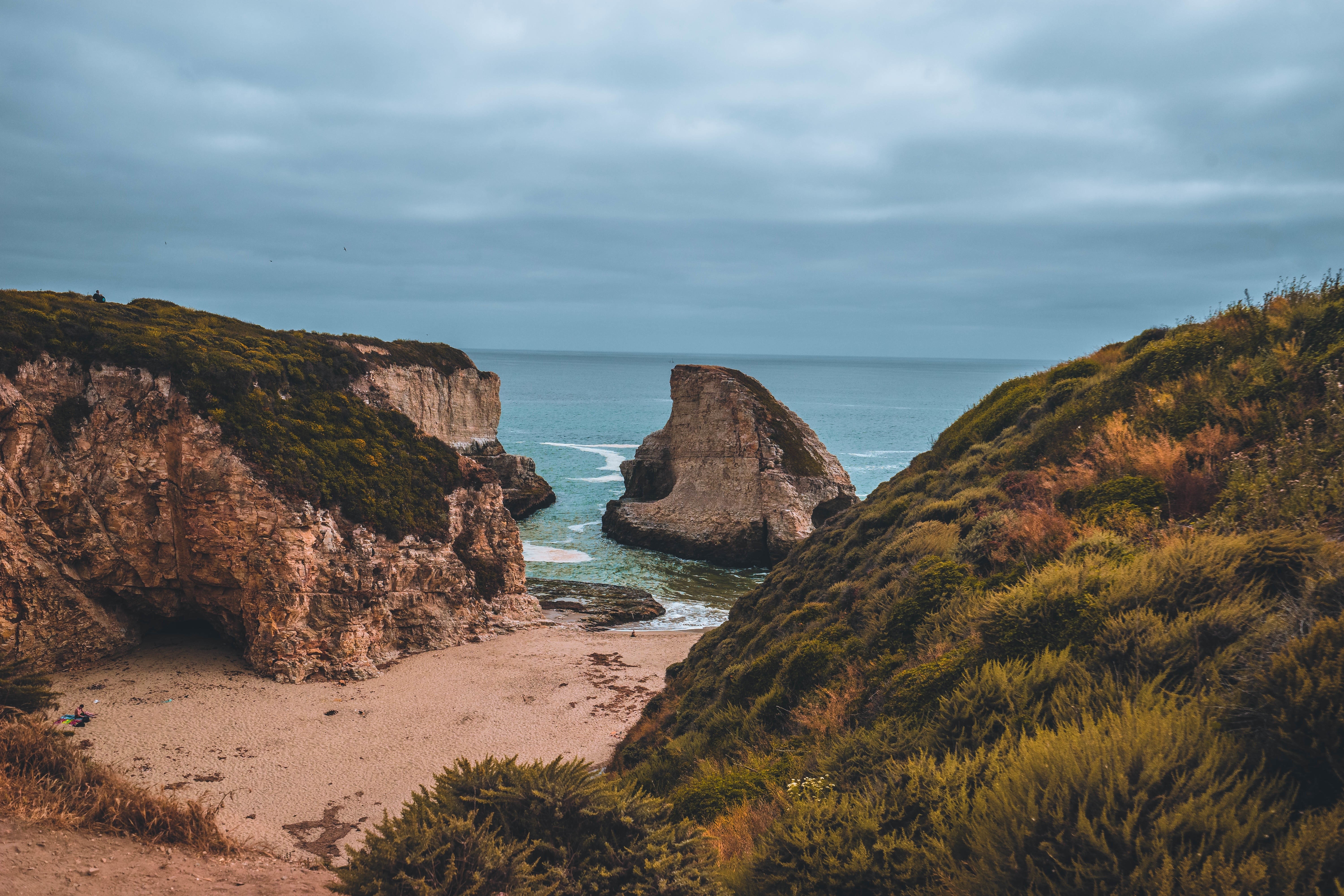 Rocky coast with a sandy beach and sea stacks HD Wallpaper