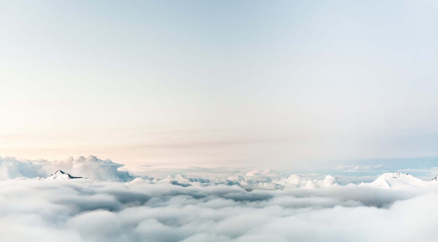 Snow-capped mountains above clouds at dawn HD Wallpaper