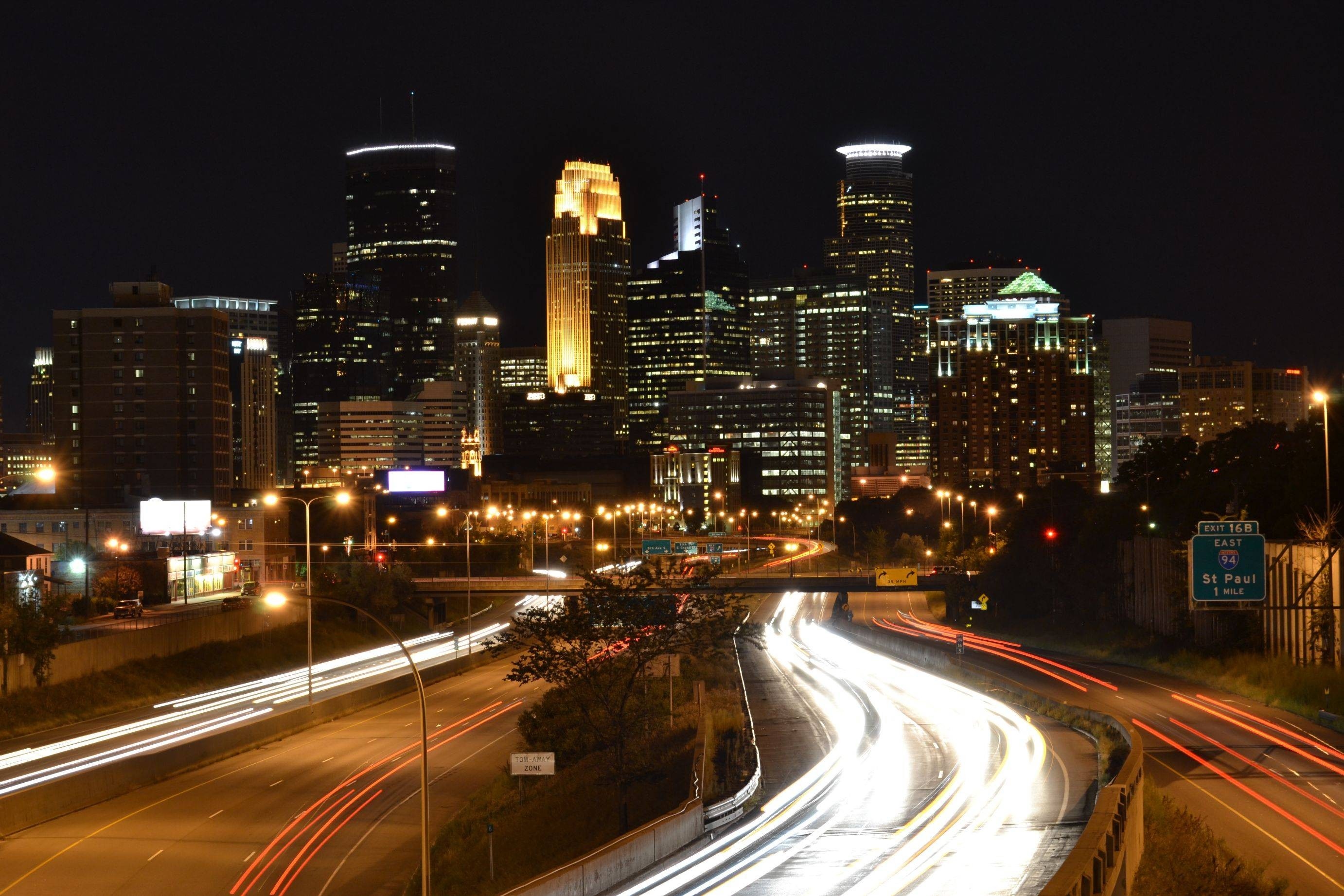 Cityscape at night with light trails on highway HD Wallpaper