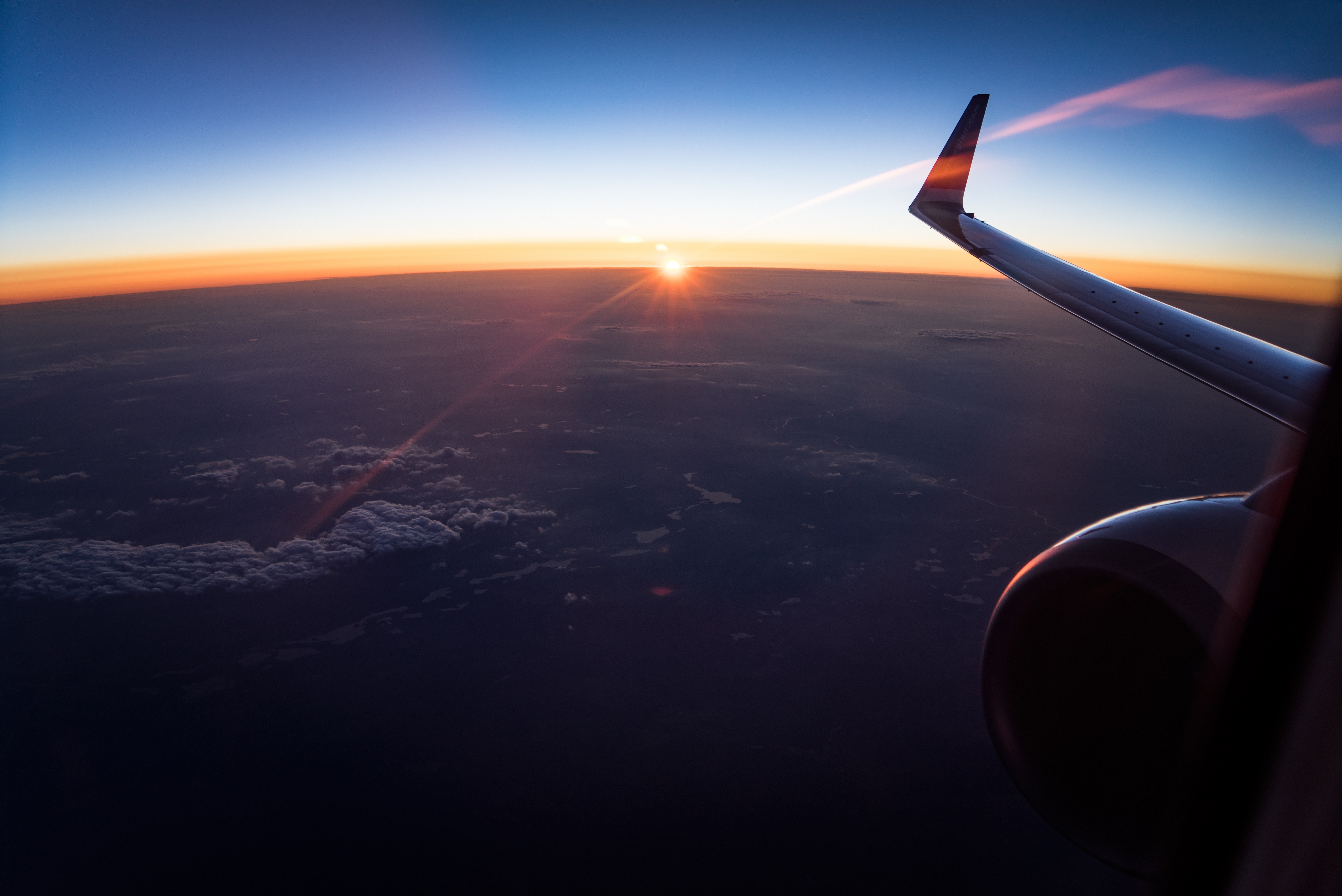 Airplane wing at sunset over clouds HD Wallpaper