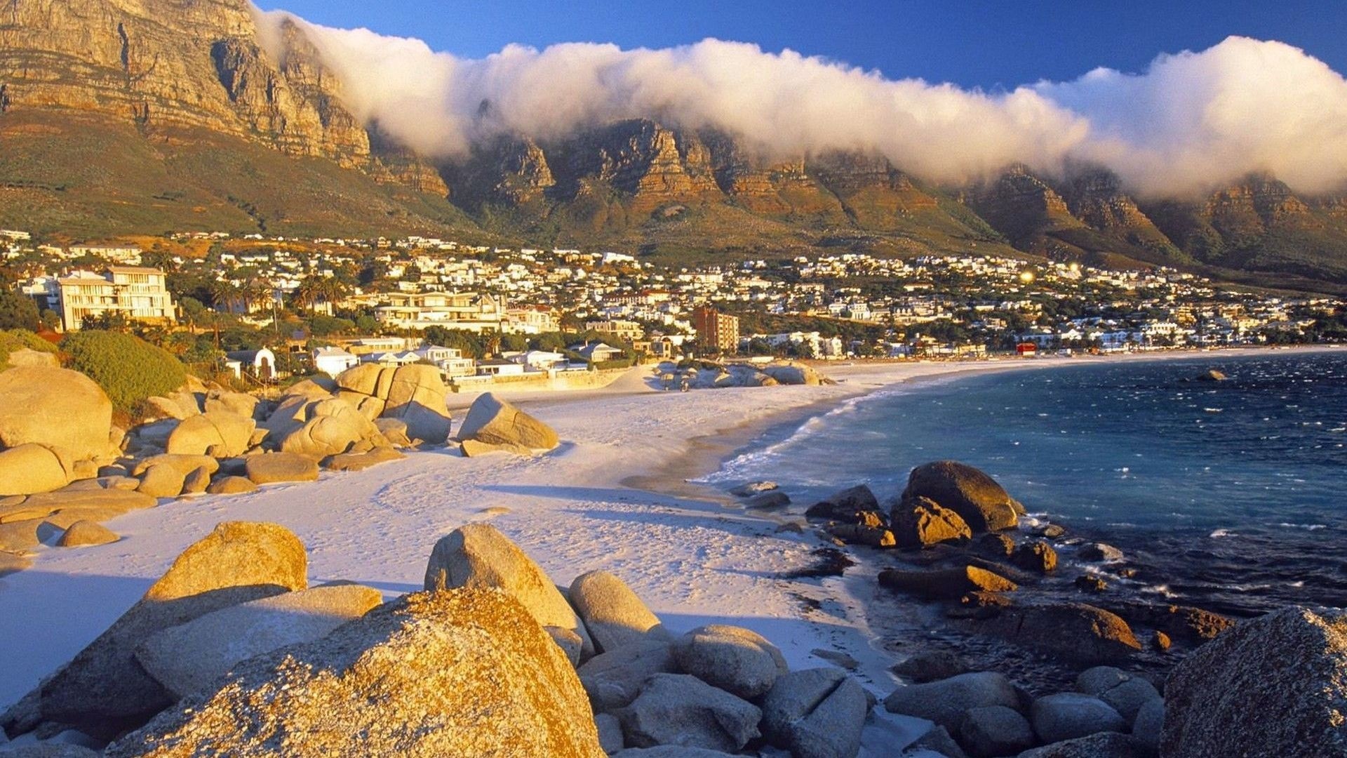 Coastal town at the foot of a mountain range HD Wallpaper