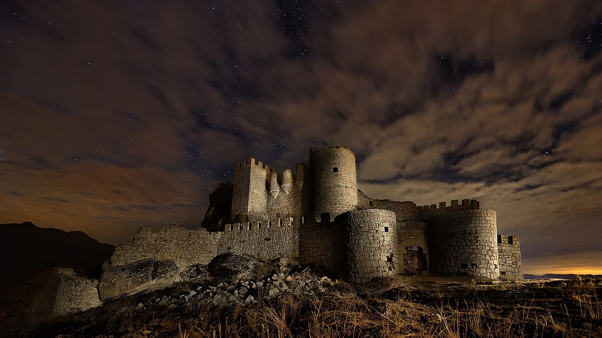 Ancient castle ruins under a starry night sky HD Wallpaper