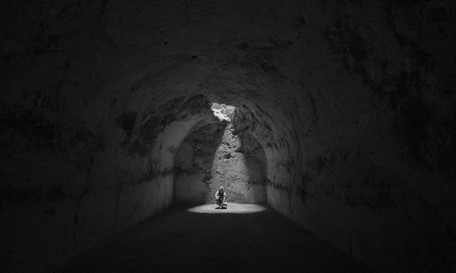 Person in a beam of light in a dark cave HD Wallpaper