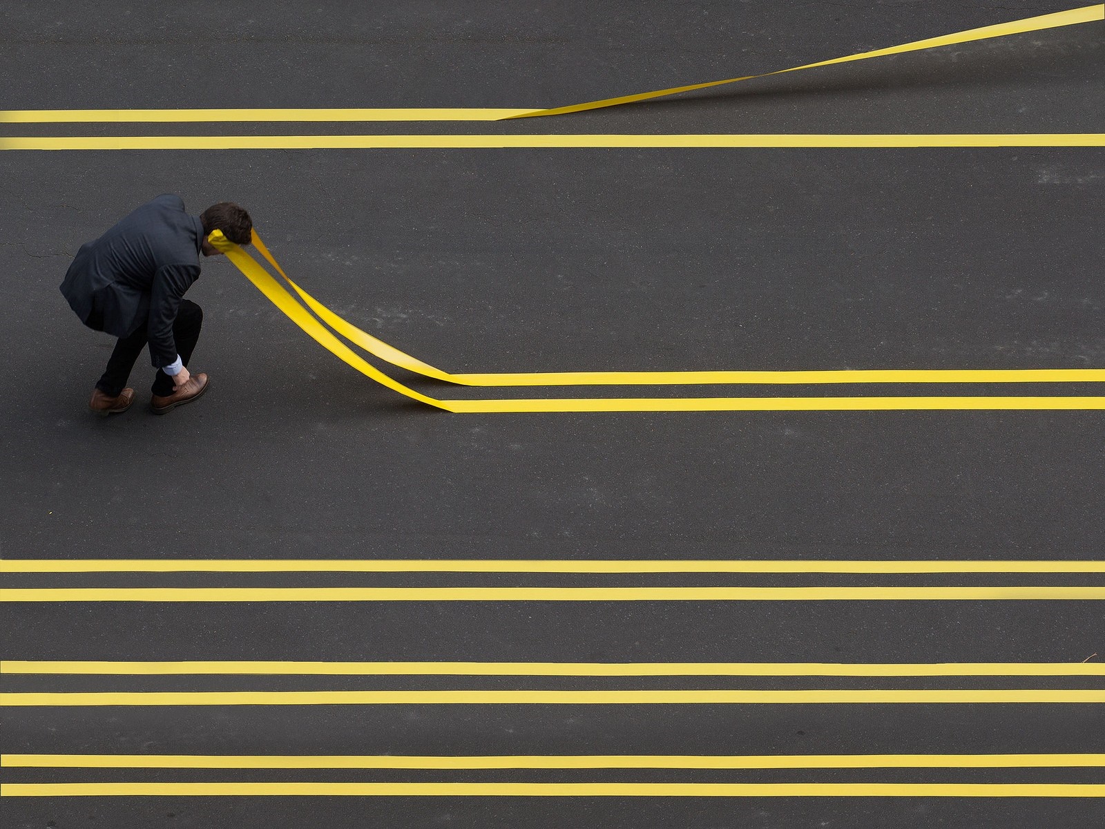 Man applying yellow tape lines on asphalt road HD Wallpaper