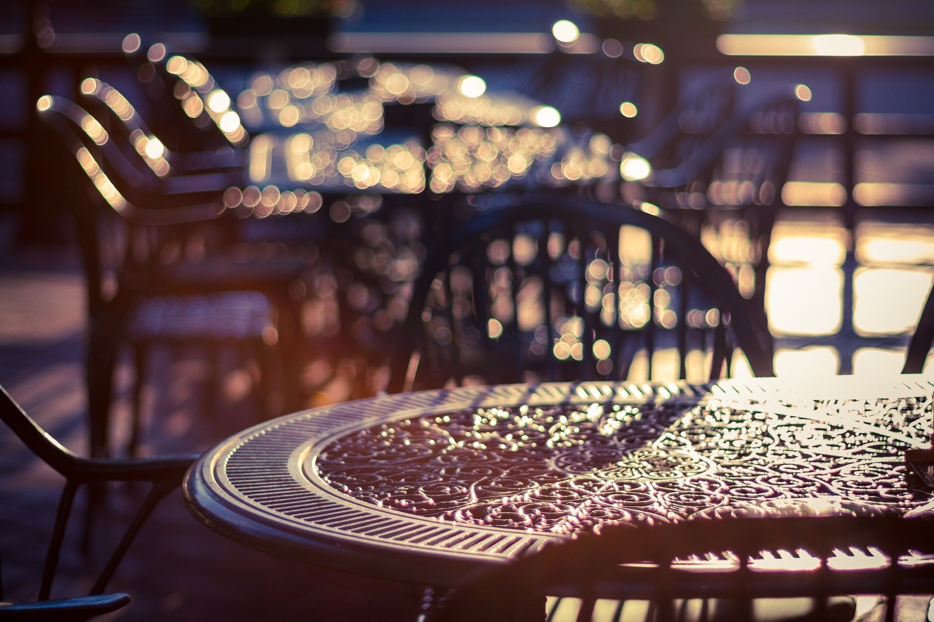 Outdoor cafe tables and chairs with bokeh lights HD Wallpaper