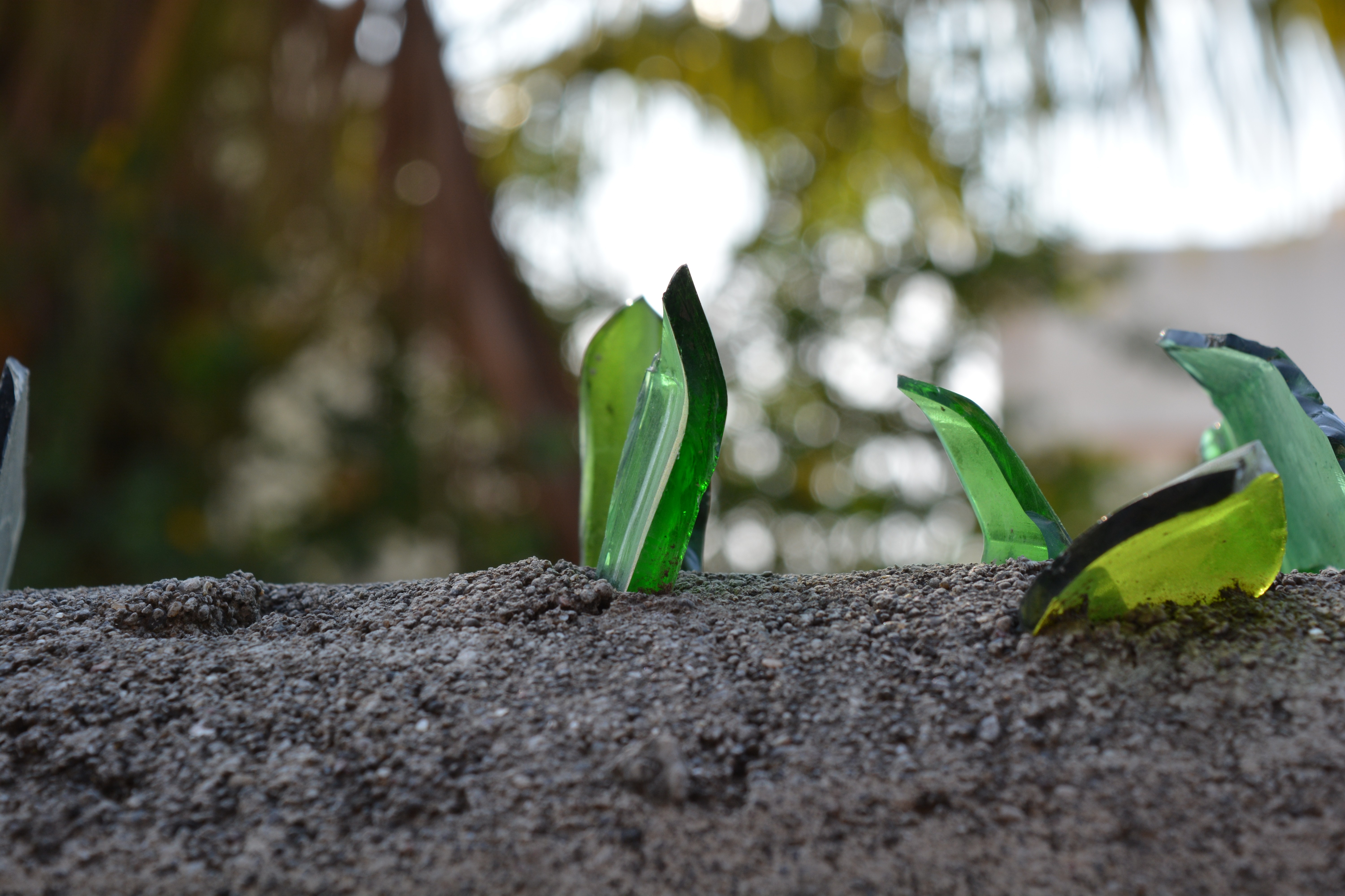 Broken glass shards on a concrete wall HD Wallpaper
