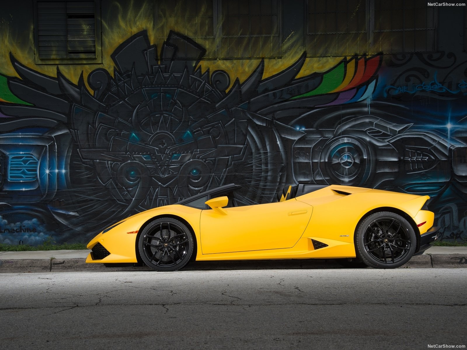 Yellow Lamborghini Huracan Spyder parked by graffiti wall HD Wallpaper