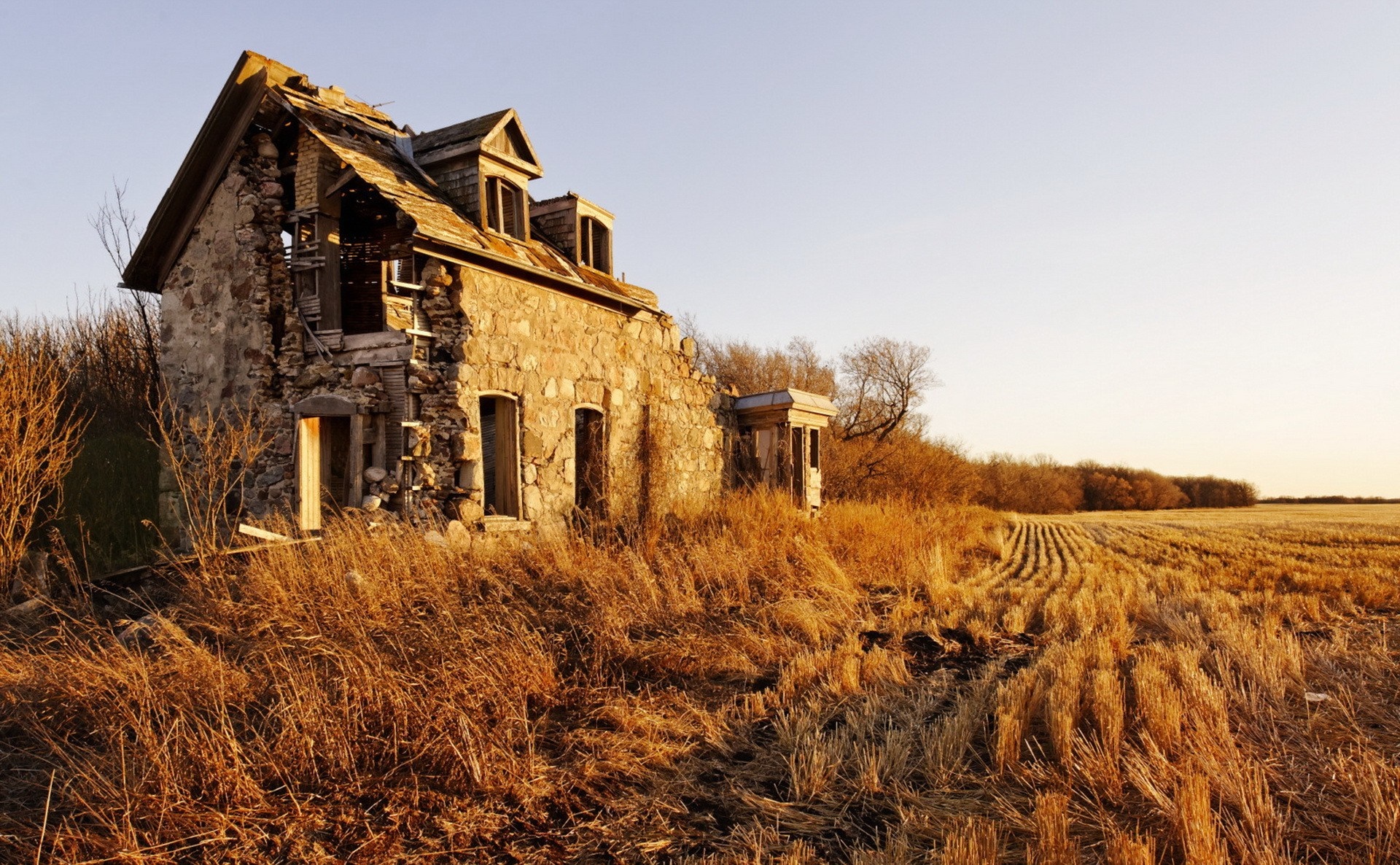 Abandoned stone house in a dry field at sunset HD Wallpaper