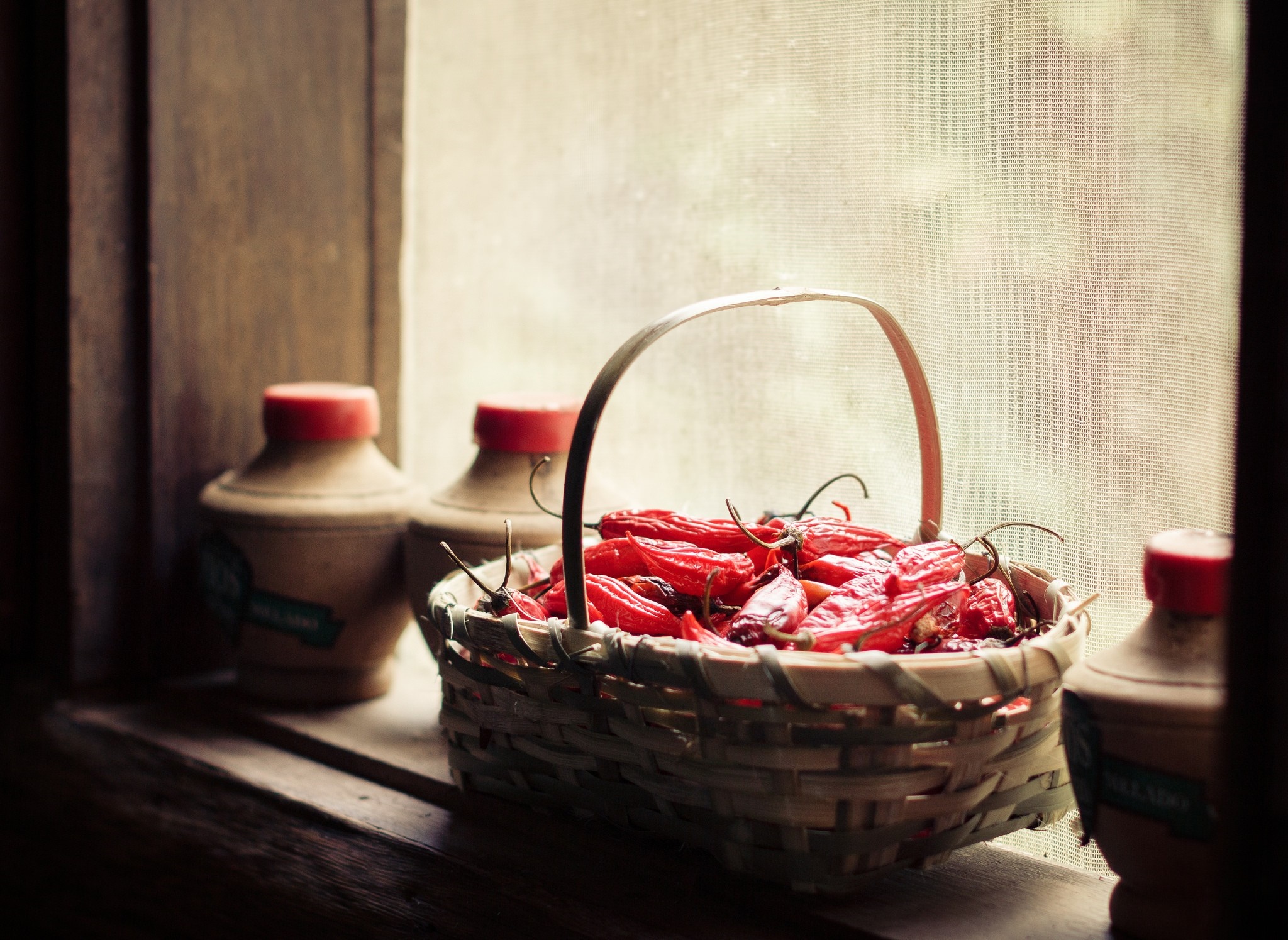 Basket of red peppers on a windowsill HD Wallpaper