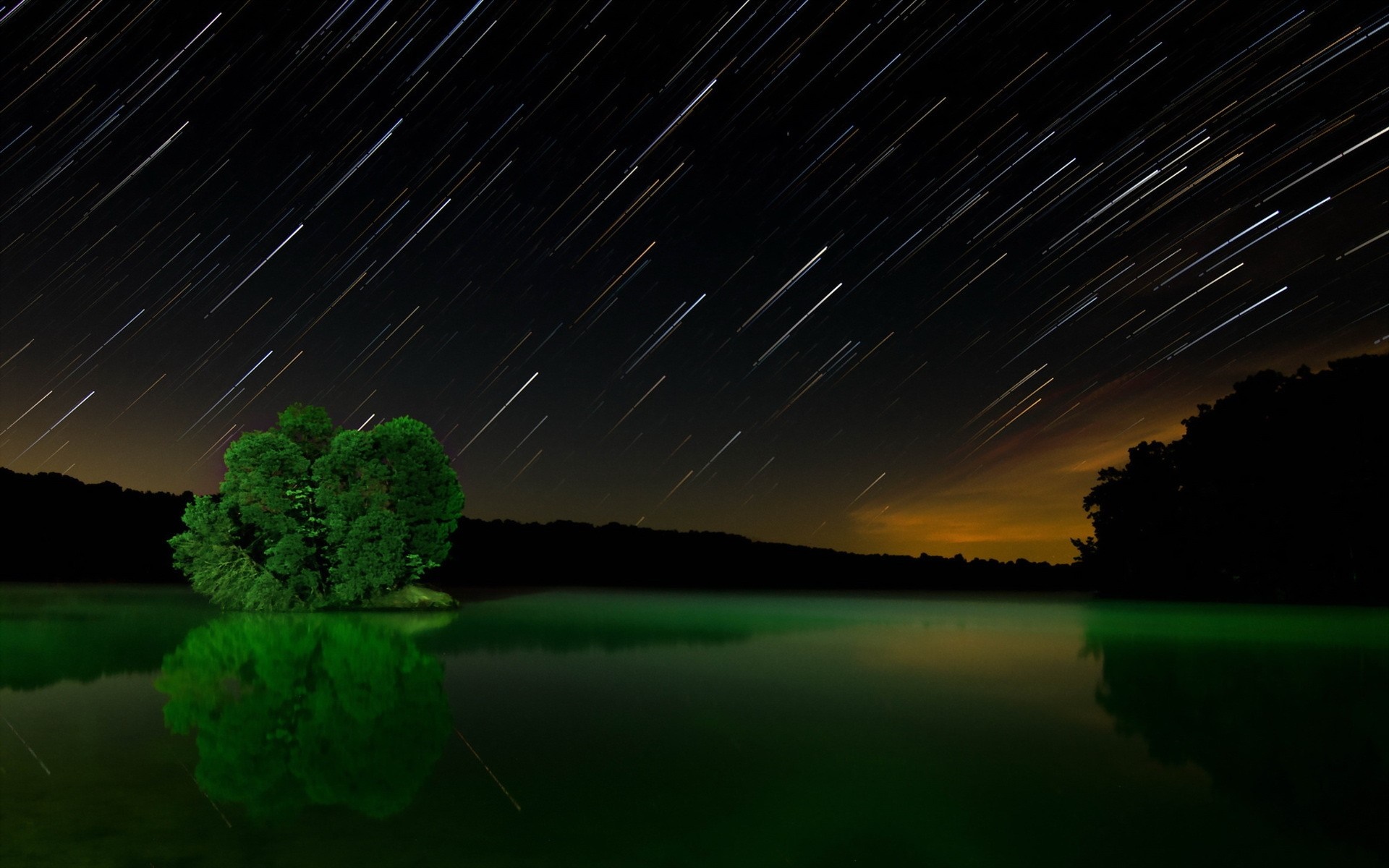 Star trails over a lake with an island of trees HD Wallpaper