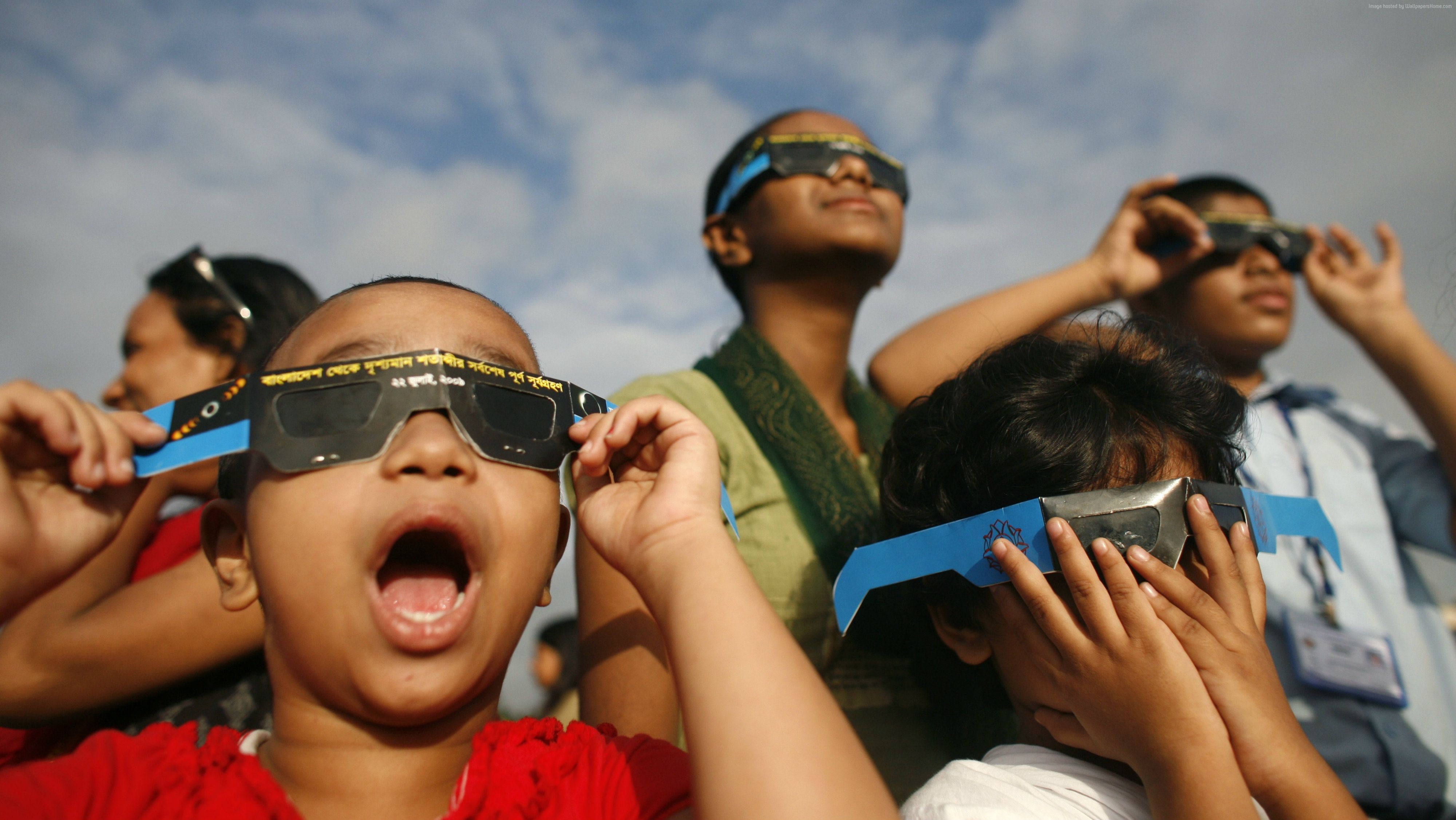 Children watching a solar eclipse with special glasses HD Wallpaper