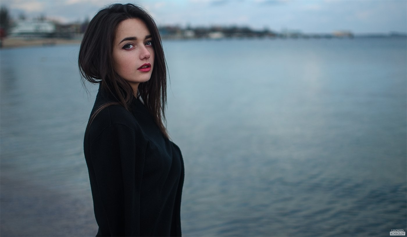 Woman with dark hair and red lipstick by the water HD Wallpaper