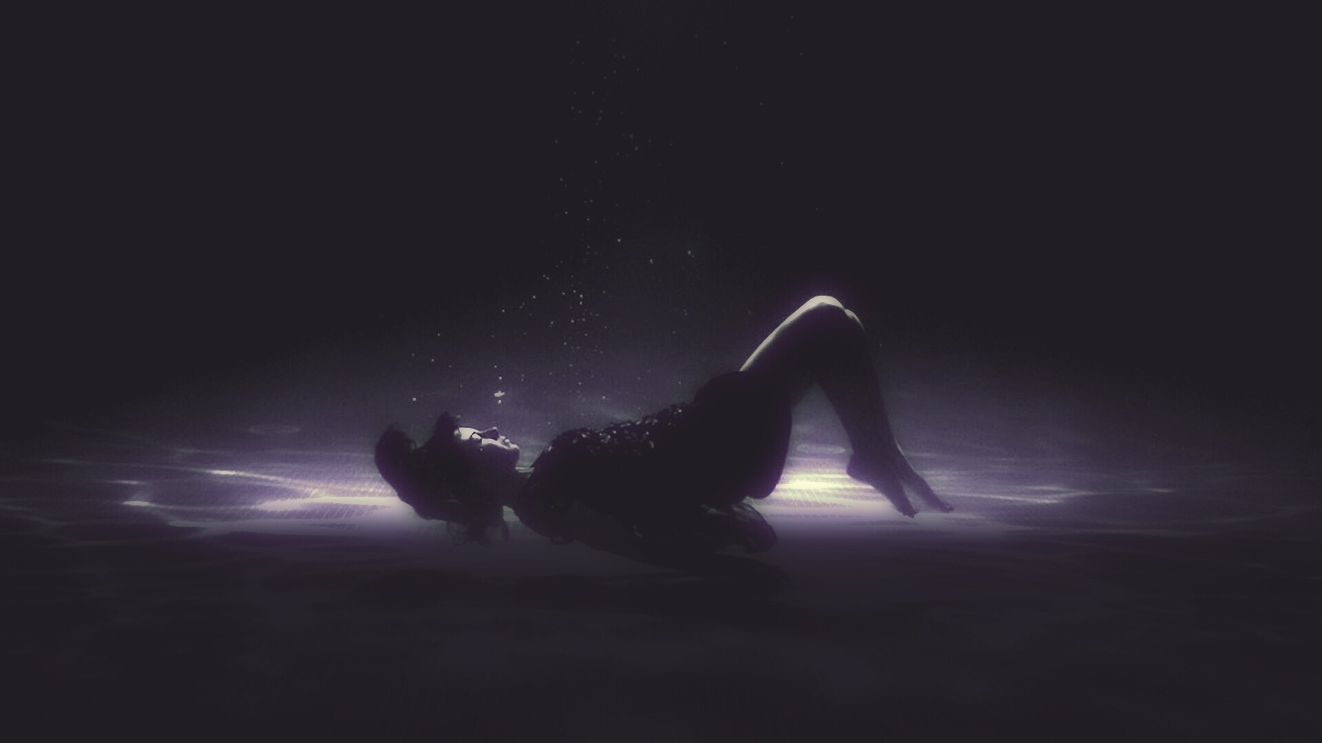 Woman floating underwater in darkness HD Wallpaper