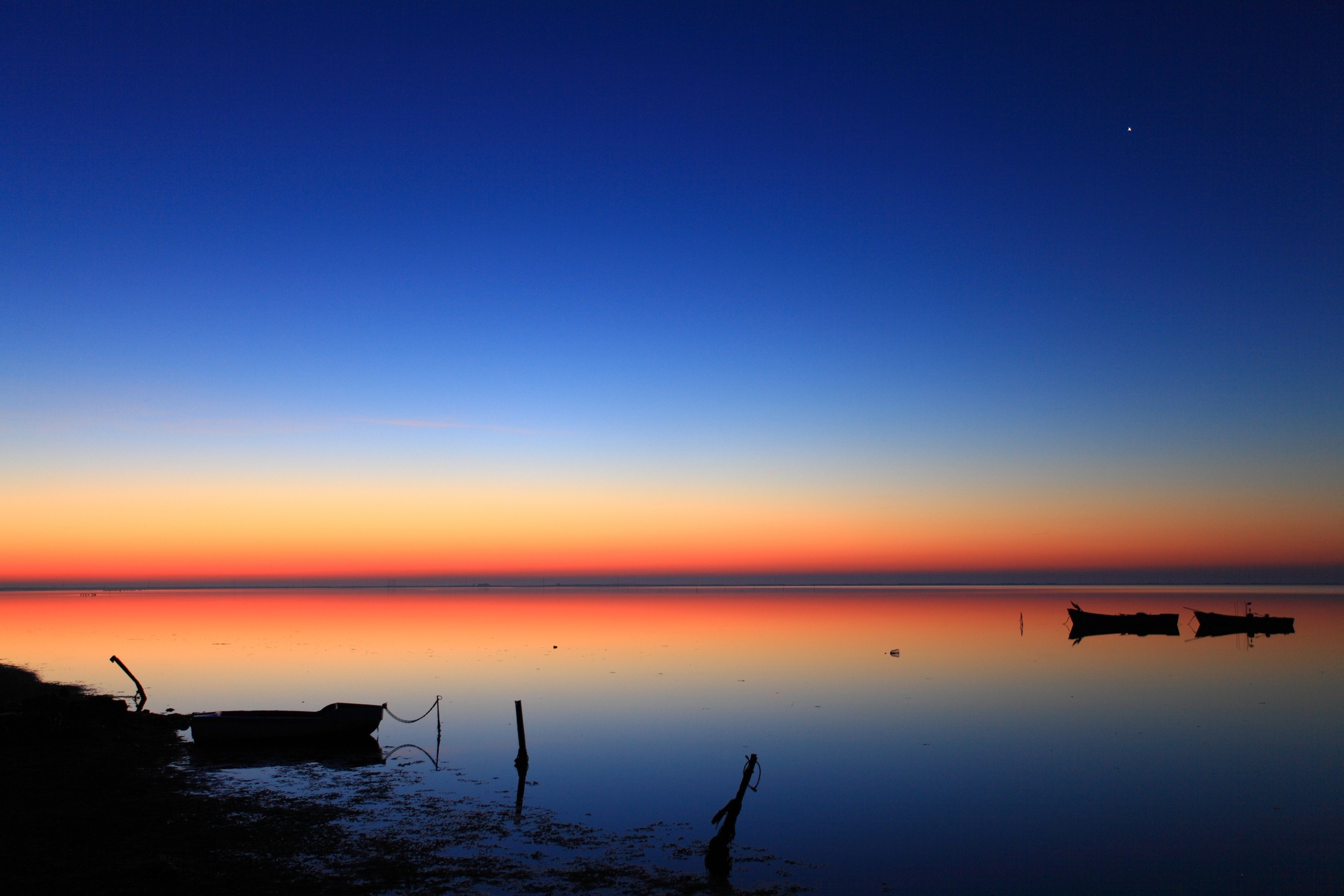 Boats on the sea at sunset with colorful sky reflection HD Wallpaper