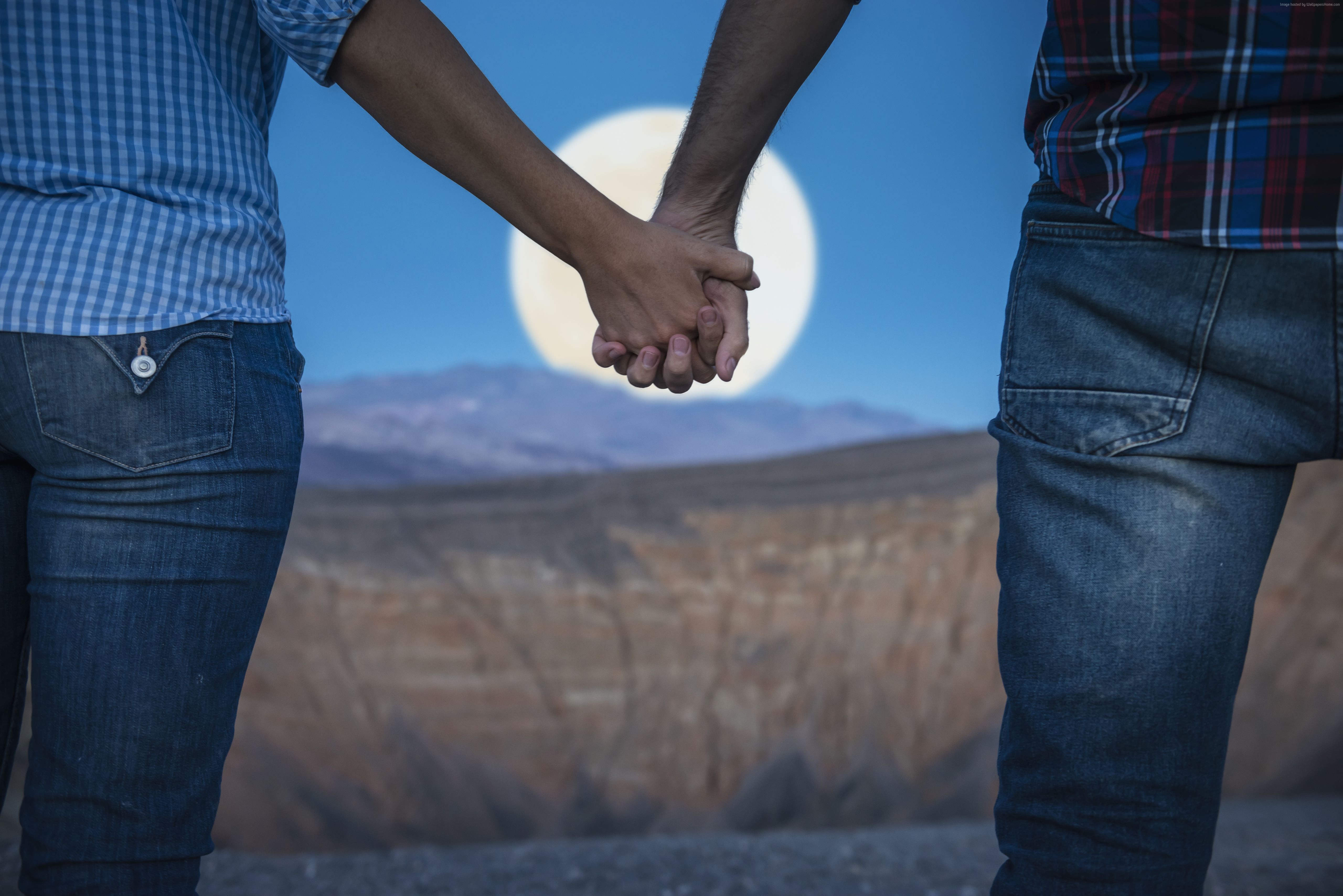 Couple holding hands in front of a full moon HD Wallpaper