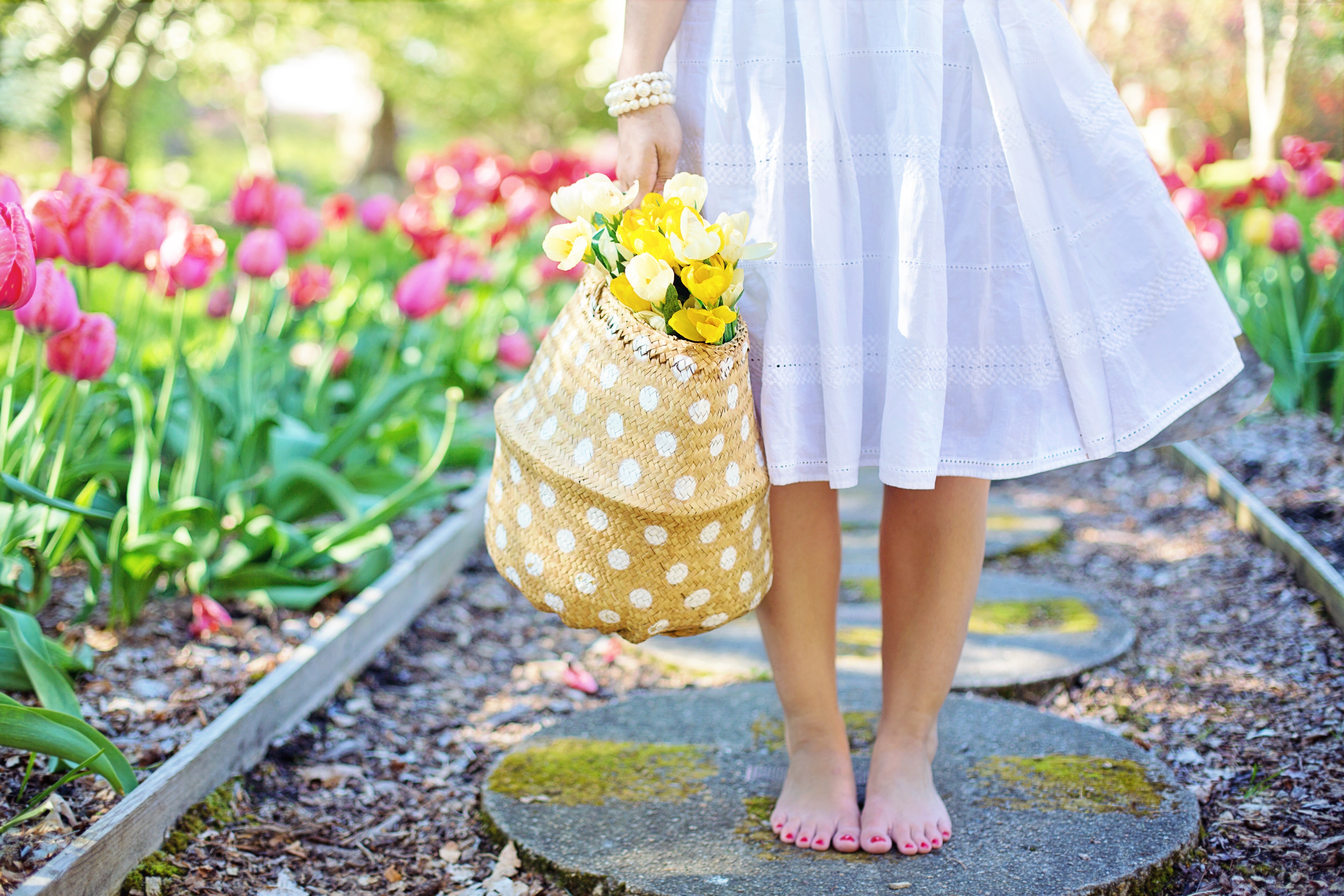 Woman in white dress holding a basket of yellow flowers HD Wallpaper