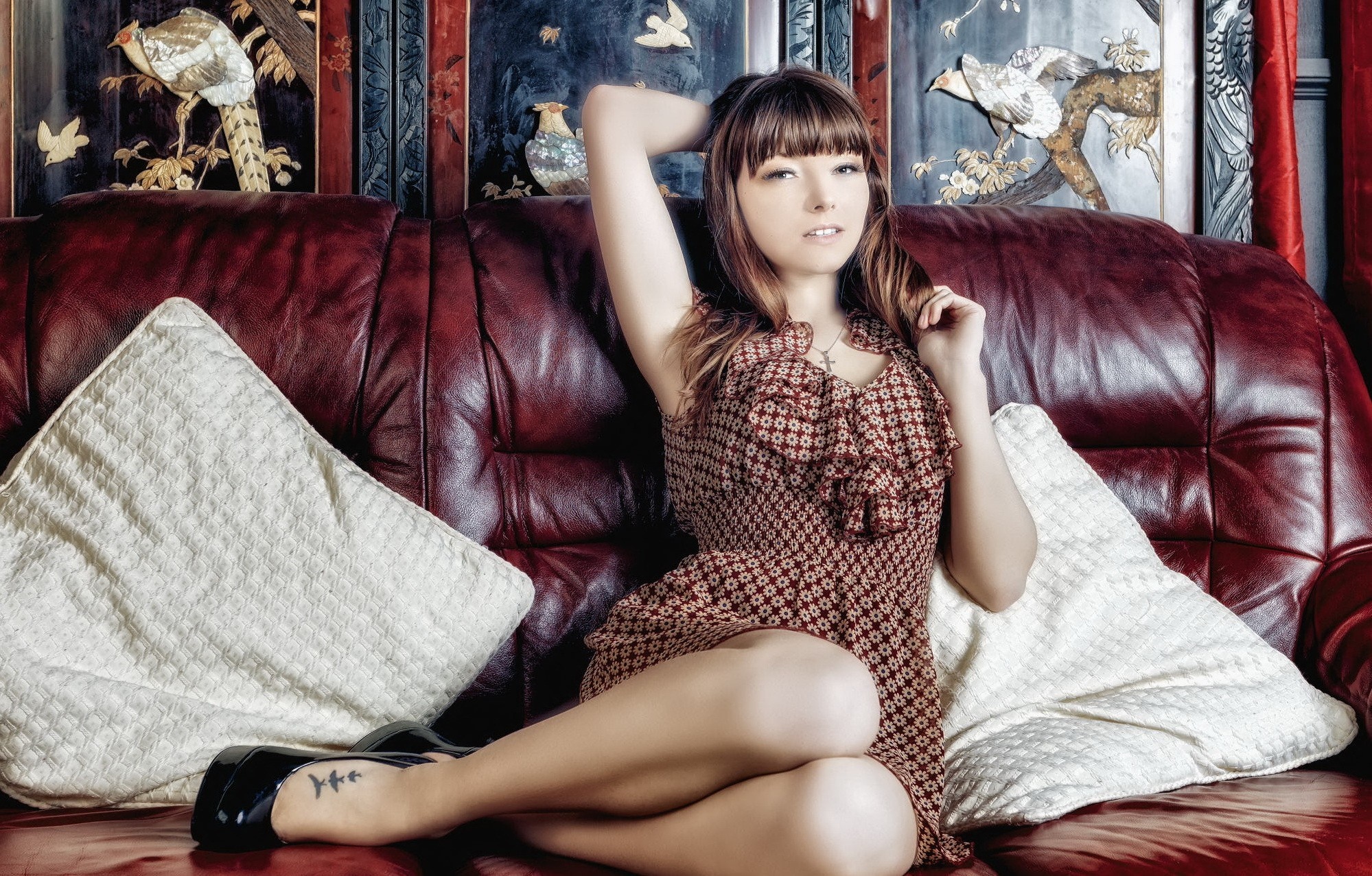 Woman sitting on a leather couch with arms up HD Wallpaper
