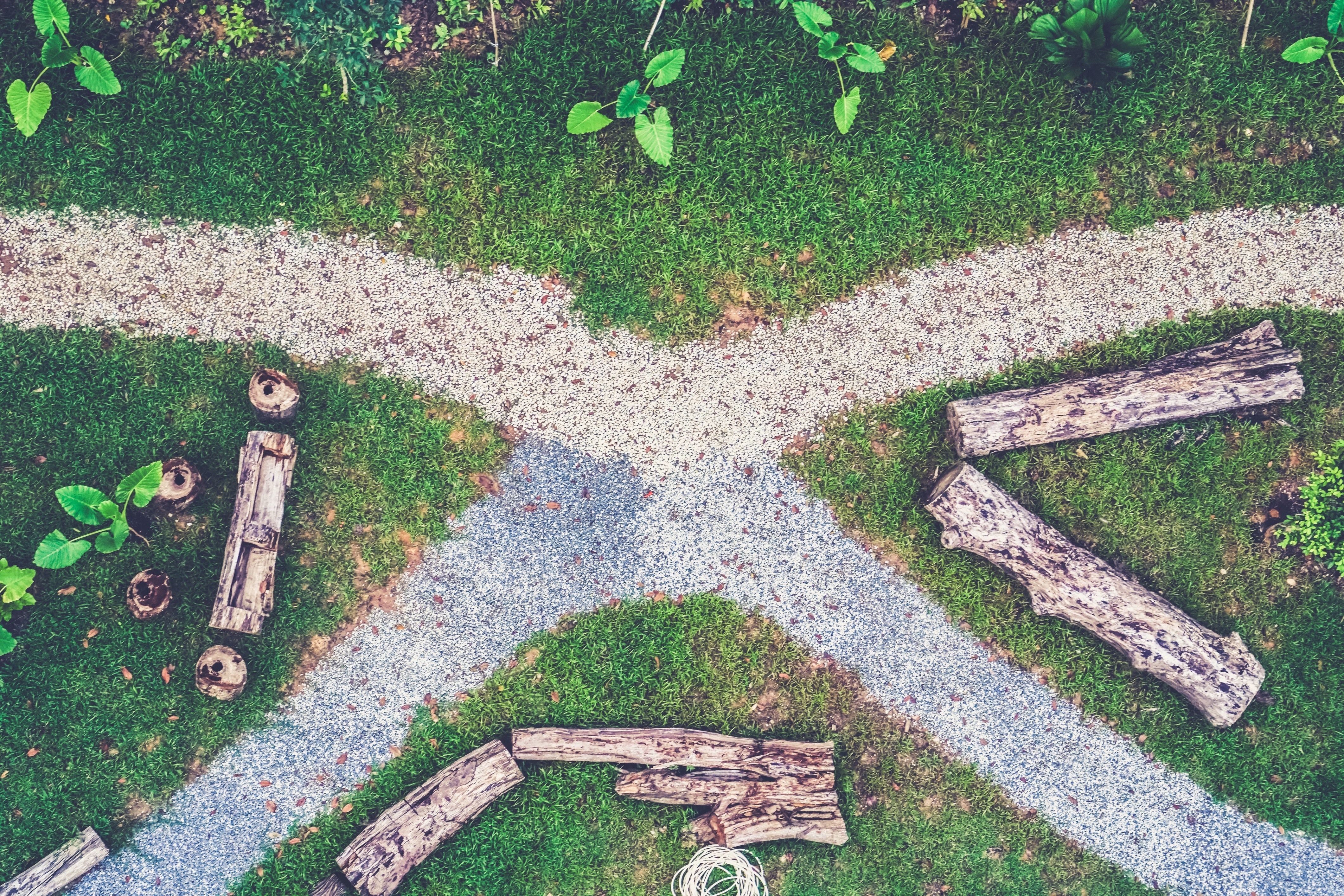Aerial view of a garden path with logs and grass HD Wallpaper
