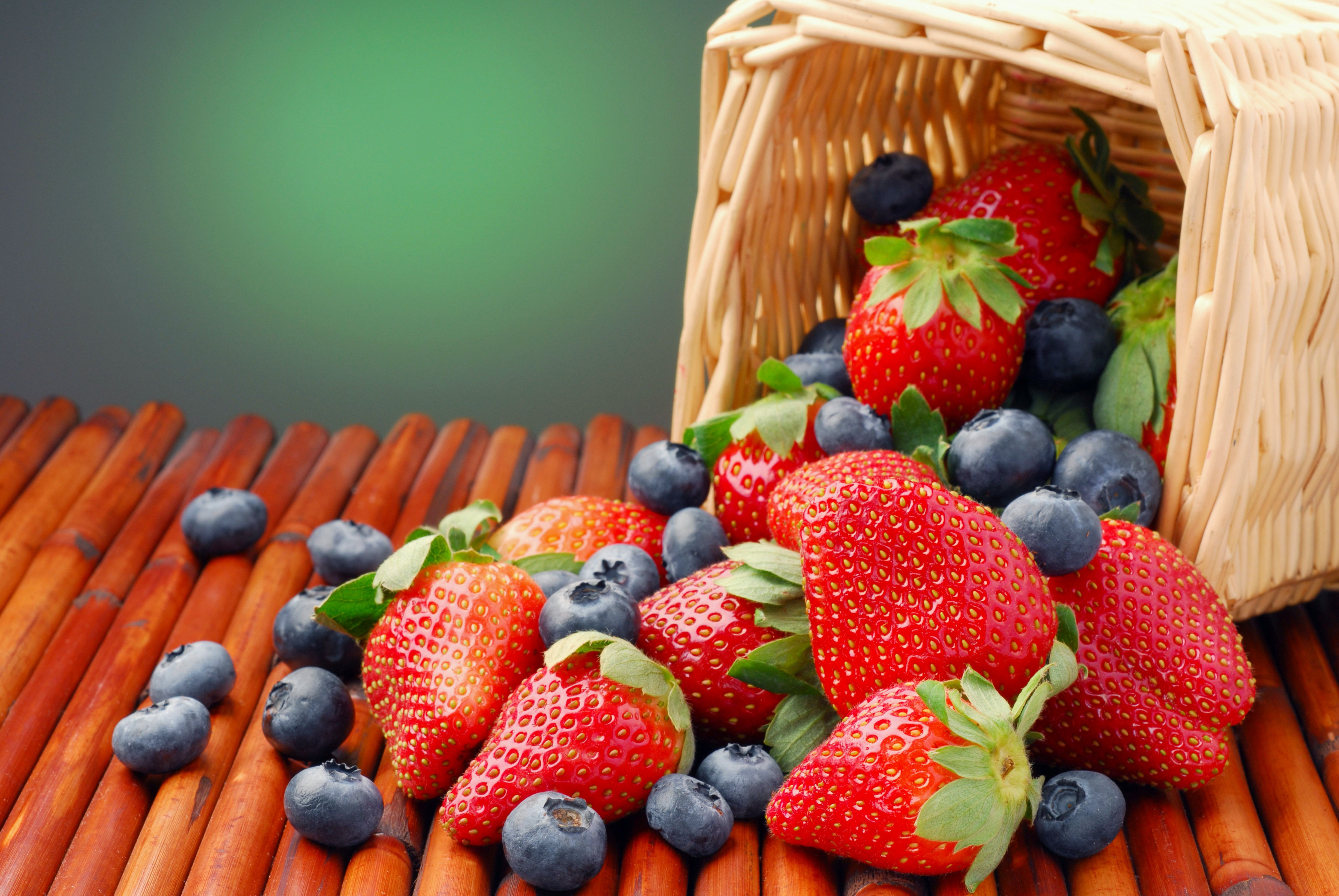 Strawberries and blueberries spilling from a basket HD Wallpaper