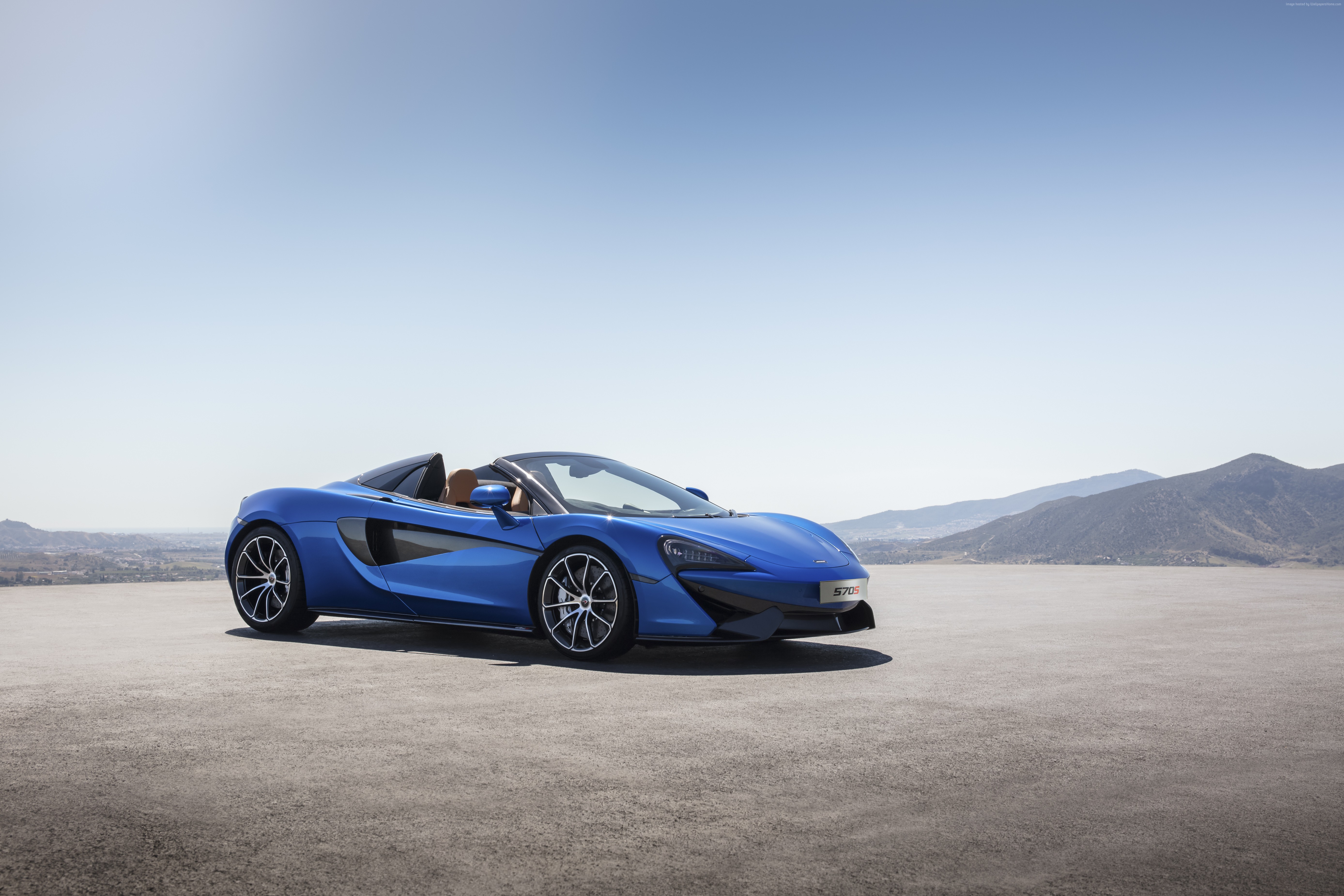 Blue McLaren 570S Spider convertible in a landscape HD Wallpaper