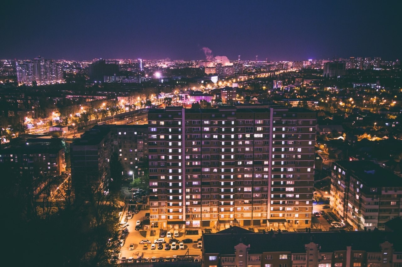 Aerial view of a city at night with illuminated buildings HD Wallpaper