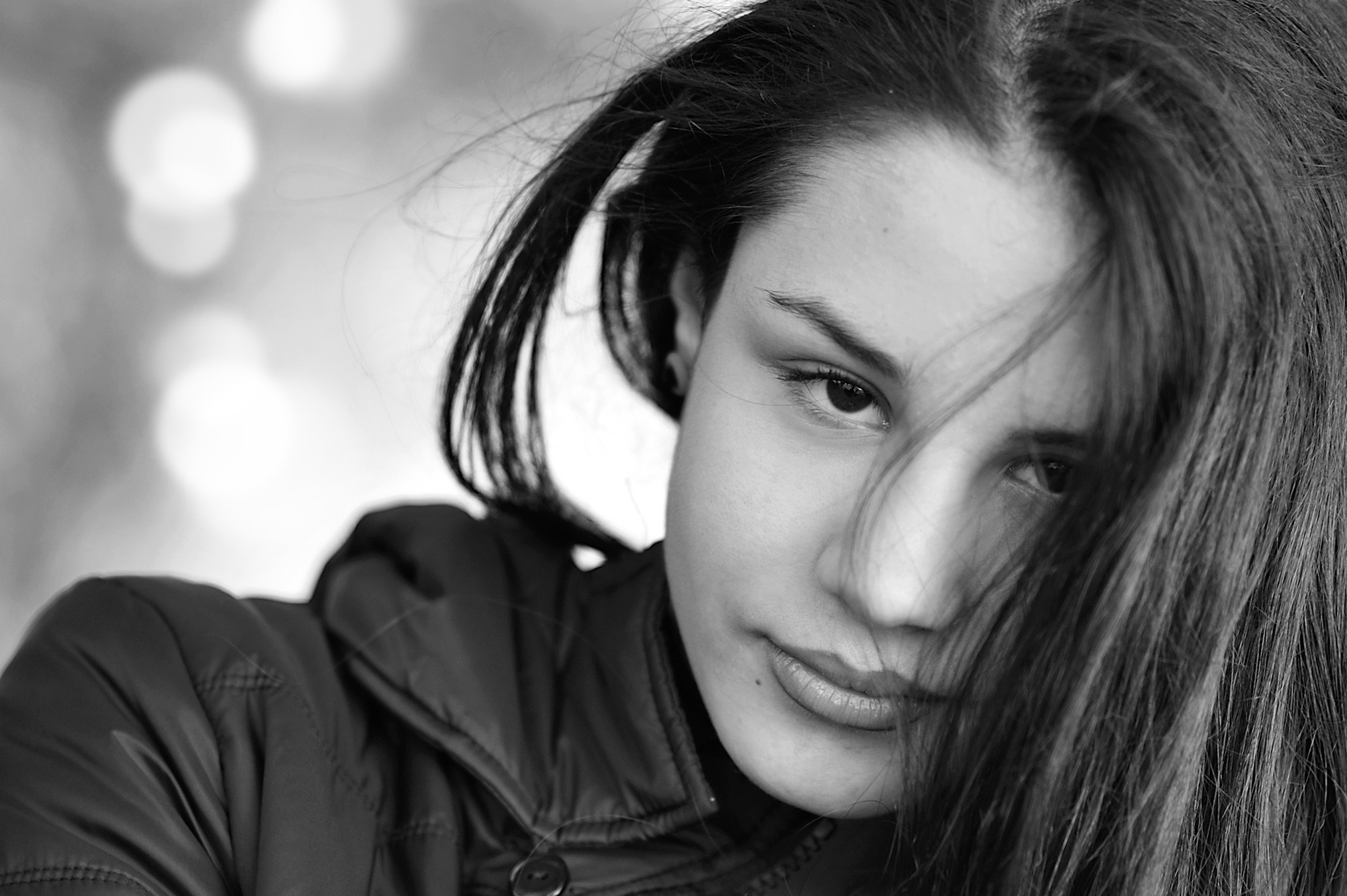Monochrome portrait of a young woman with hair across her face HD Wallpaper