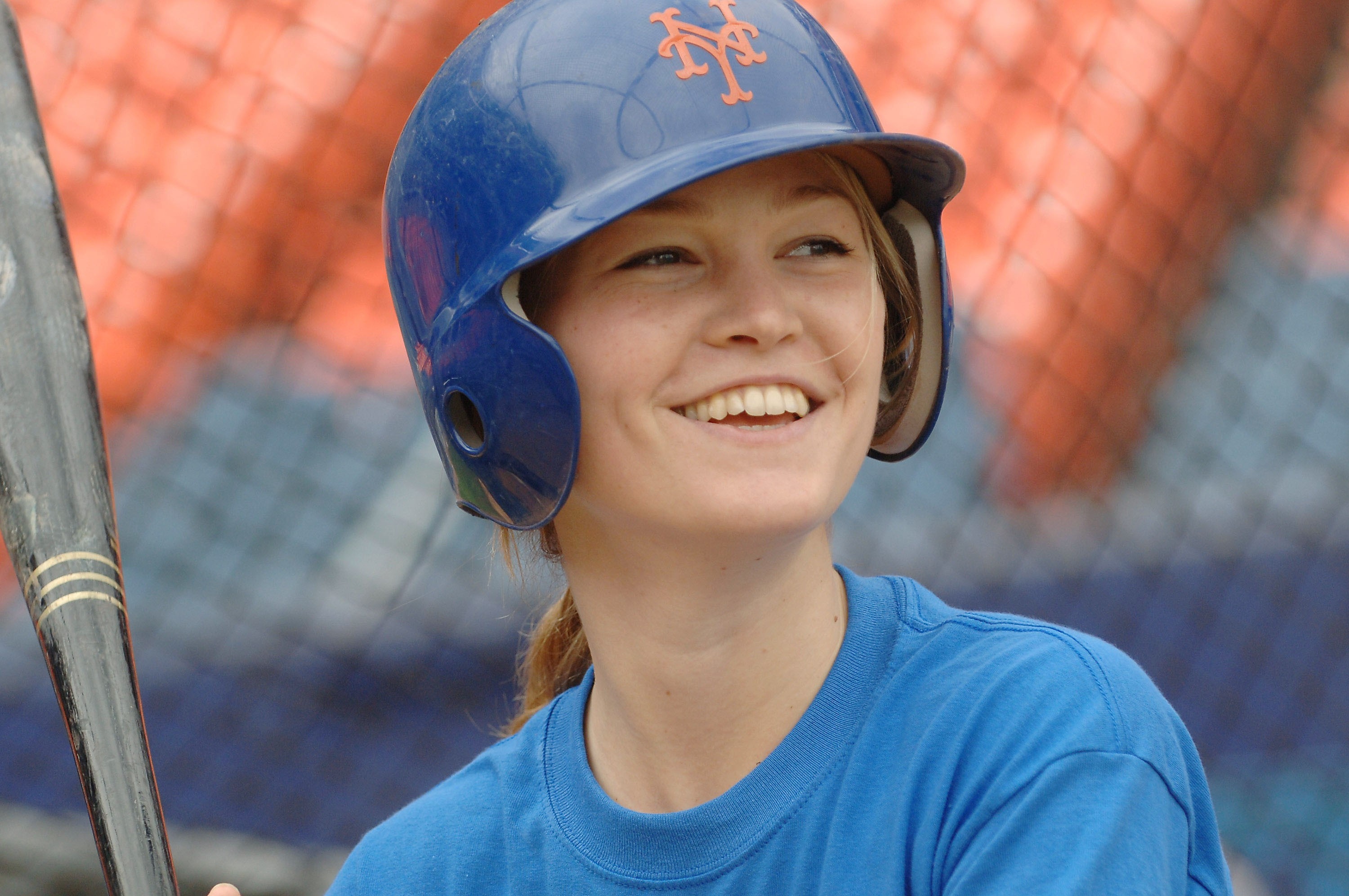Julia Stiles in a blue Mets baseball helmet and shirt holding a bat HD Wallpaper