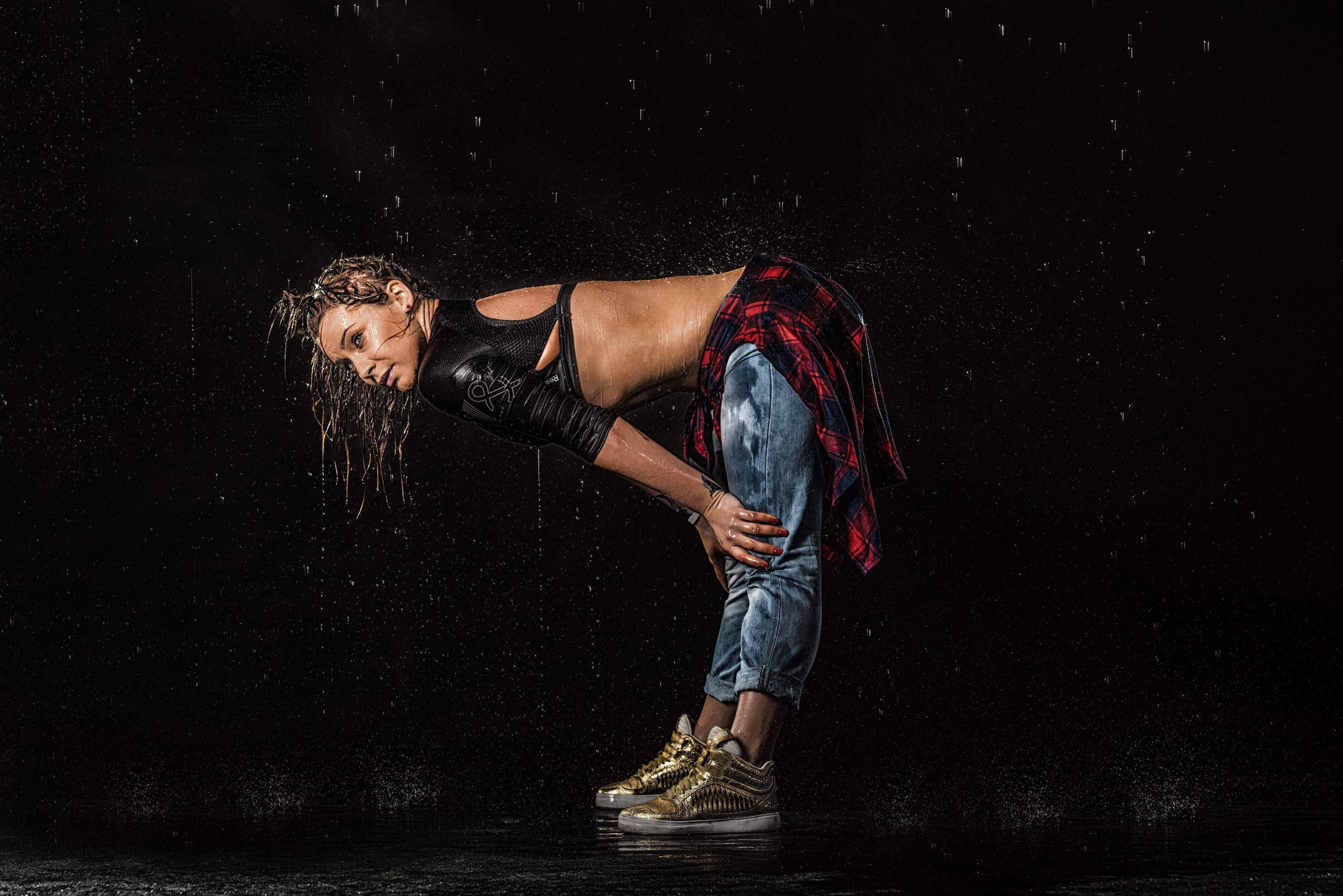 Woman dancing in the rain on a dark stage HD Wallpaper
