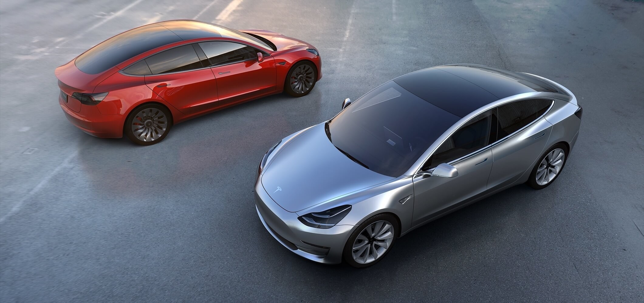 Two Tesla Model 3 electric cars on pavement HD Wallpaper