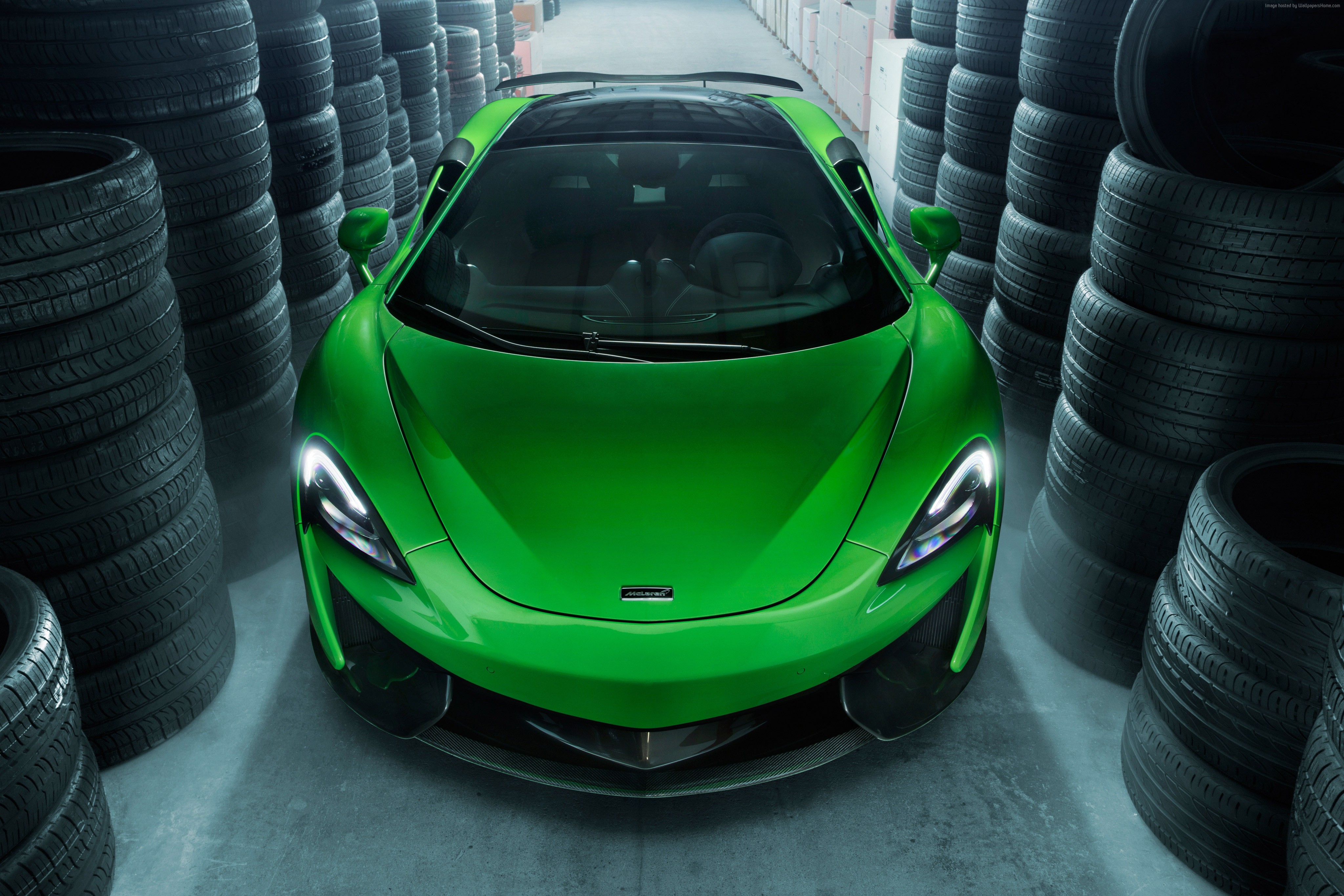 Green McLaren 570GT sports car in a tire storage HD Wallpaper